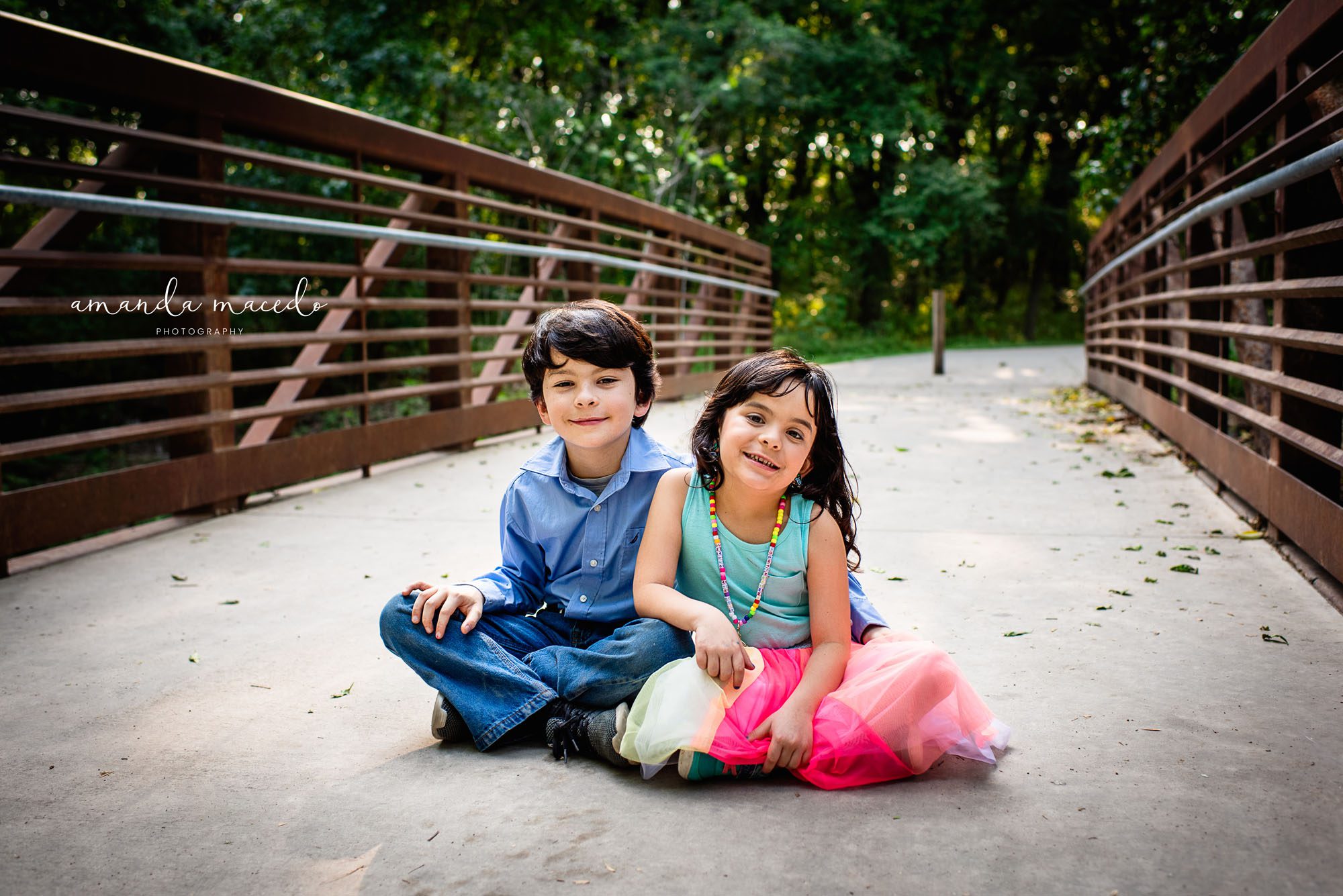 Child photographer, brother and sister on bridge smiling