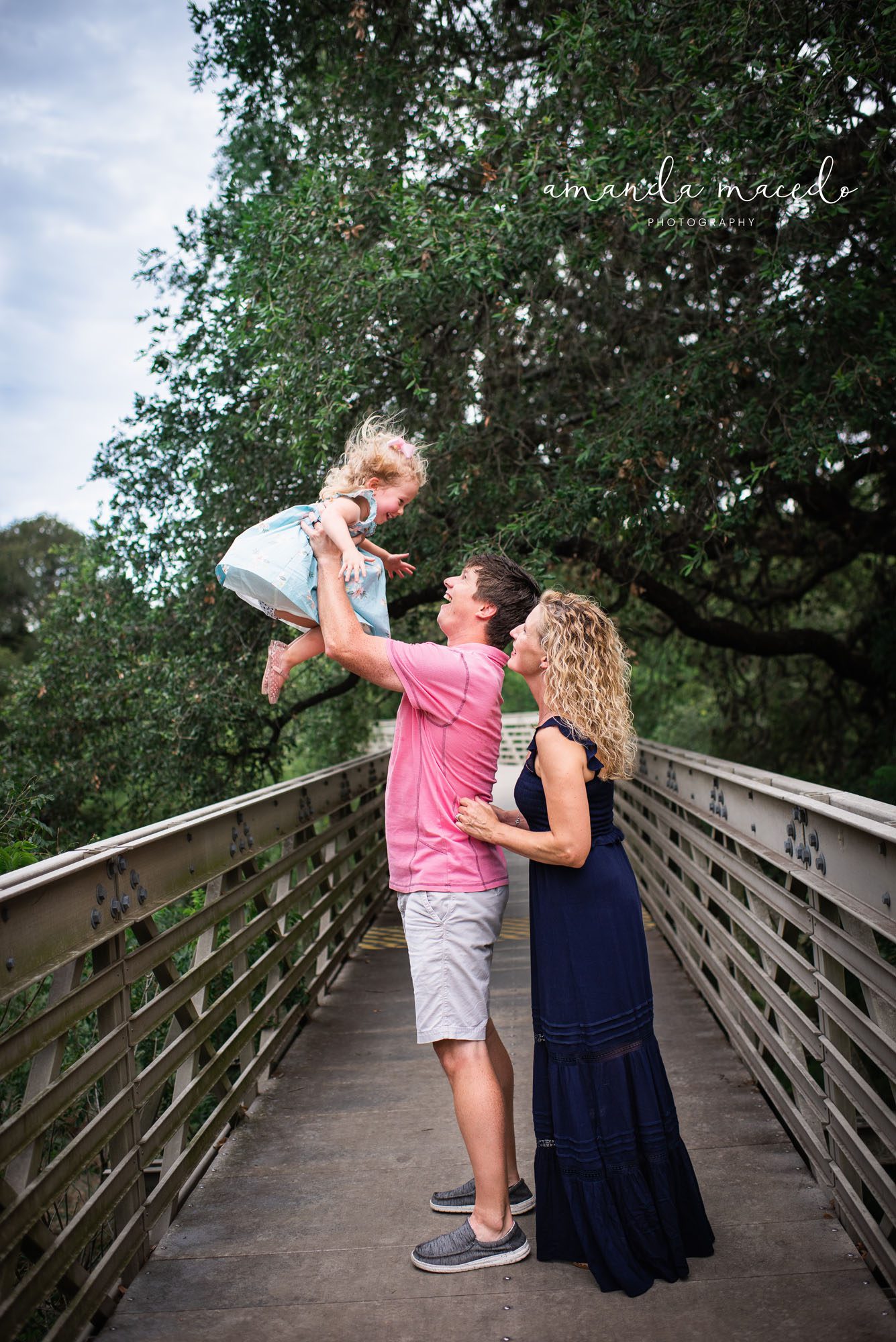 Family Photographer, Parents playing with daughter on a bridge