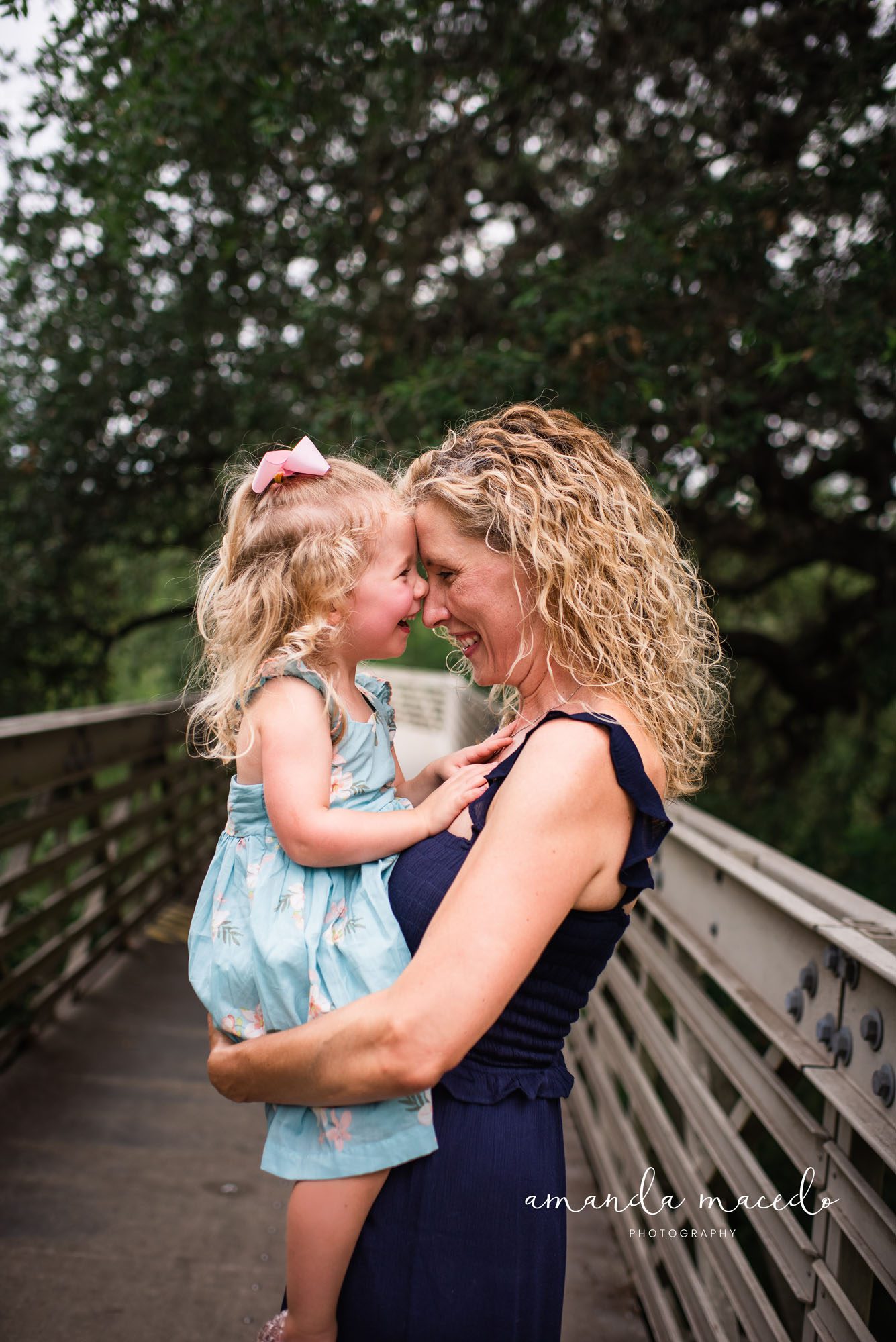 Family photographer, mom holding daughter close and smiling
