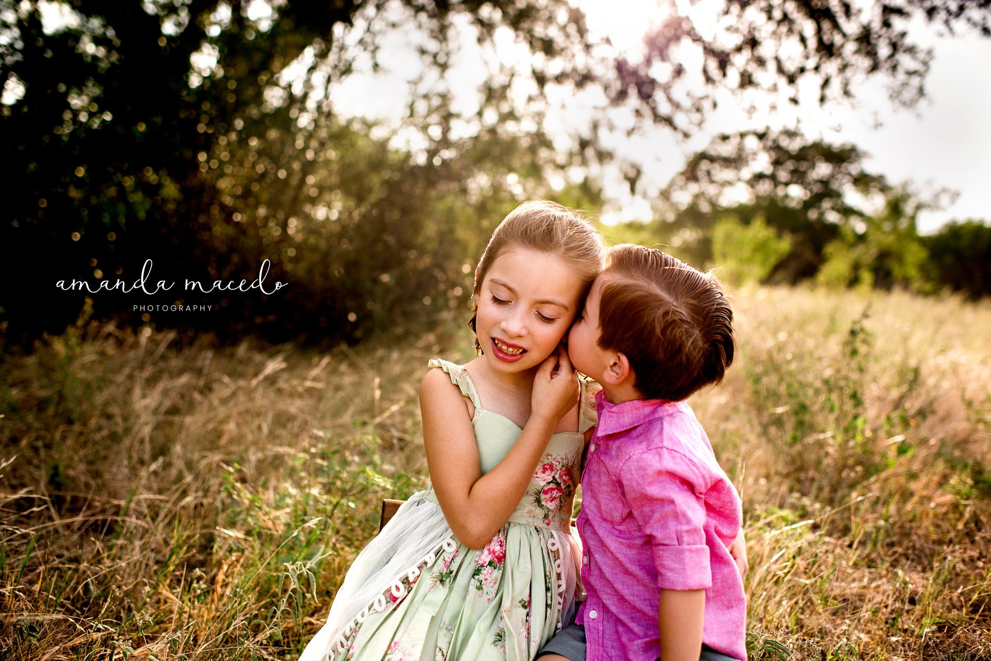 Family photographer, little brother kissing sister's cheek