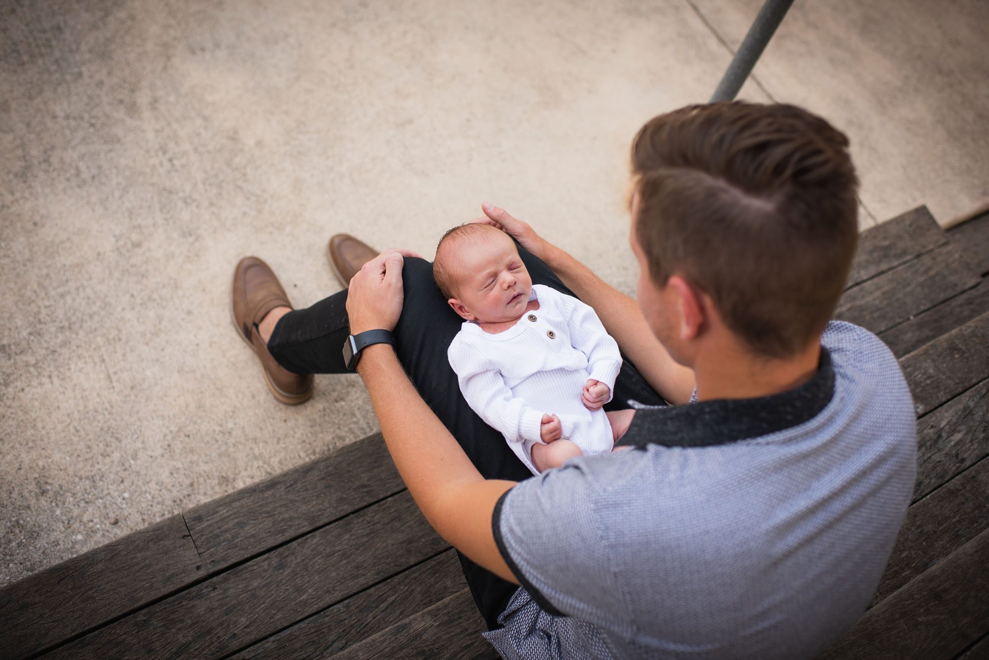 San Antonio newborn photographer, father holding newborn baby on his lap