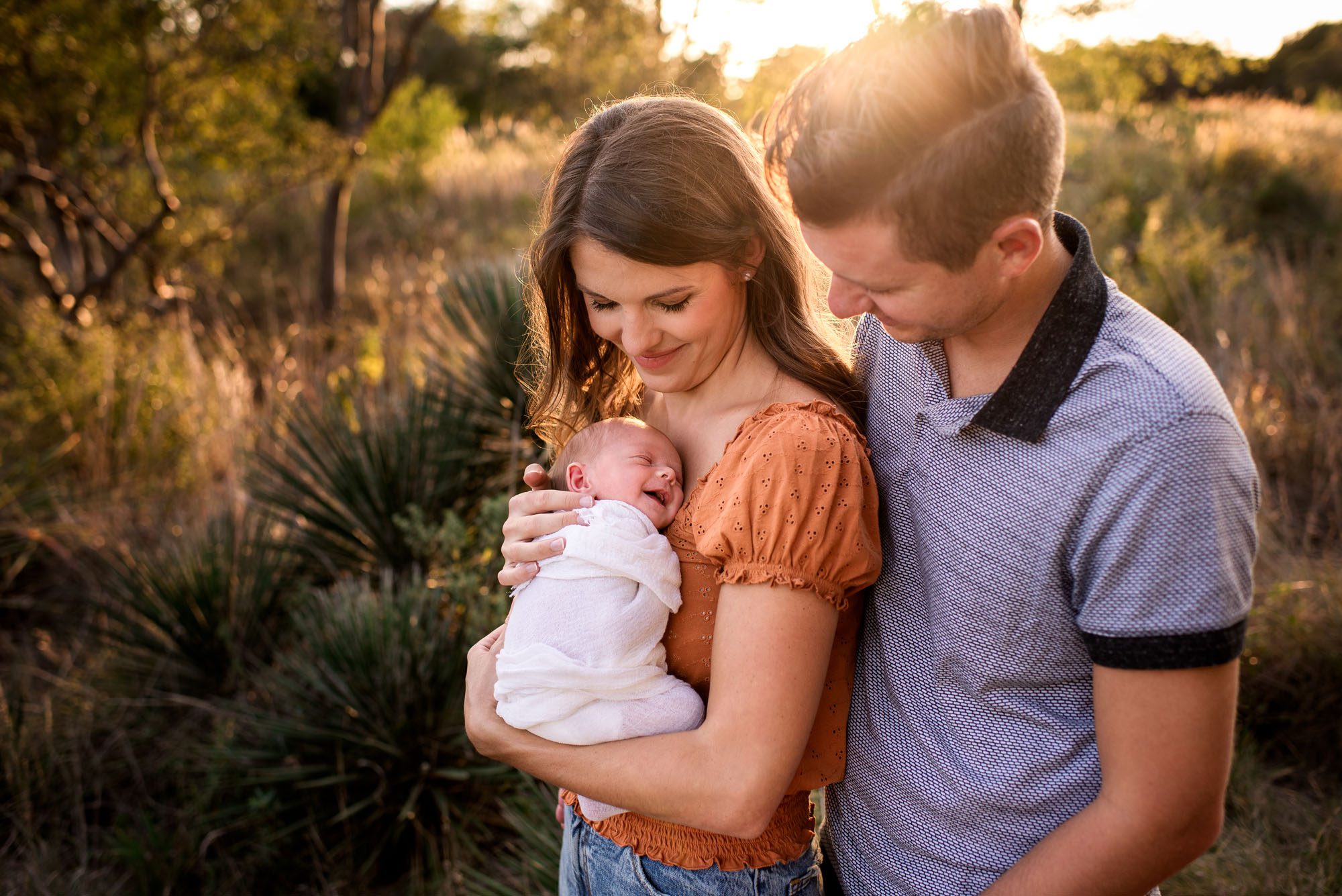 San Antonio newborn photographer, mother holding smiling newborn baby at sunset