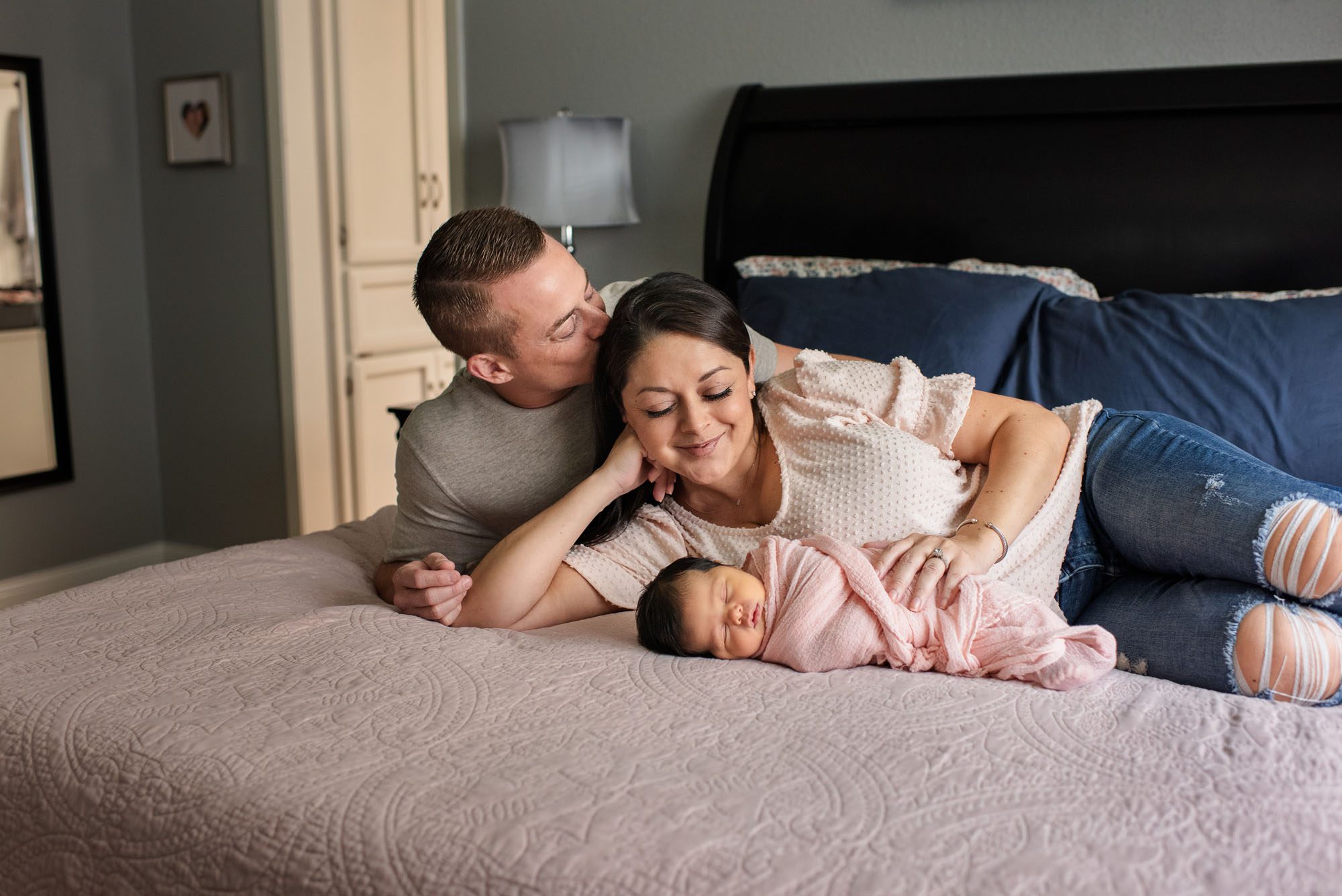 Parents holding newborn baby girl on bed, Lifestyle Newborn Photographer San Antonio