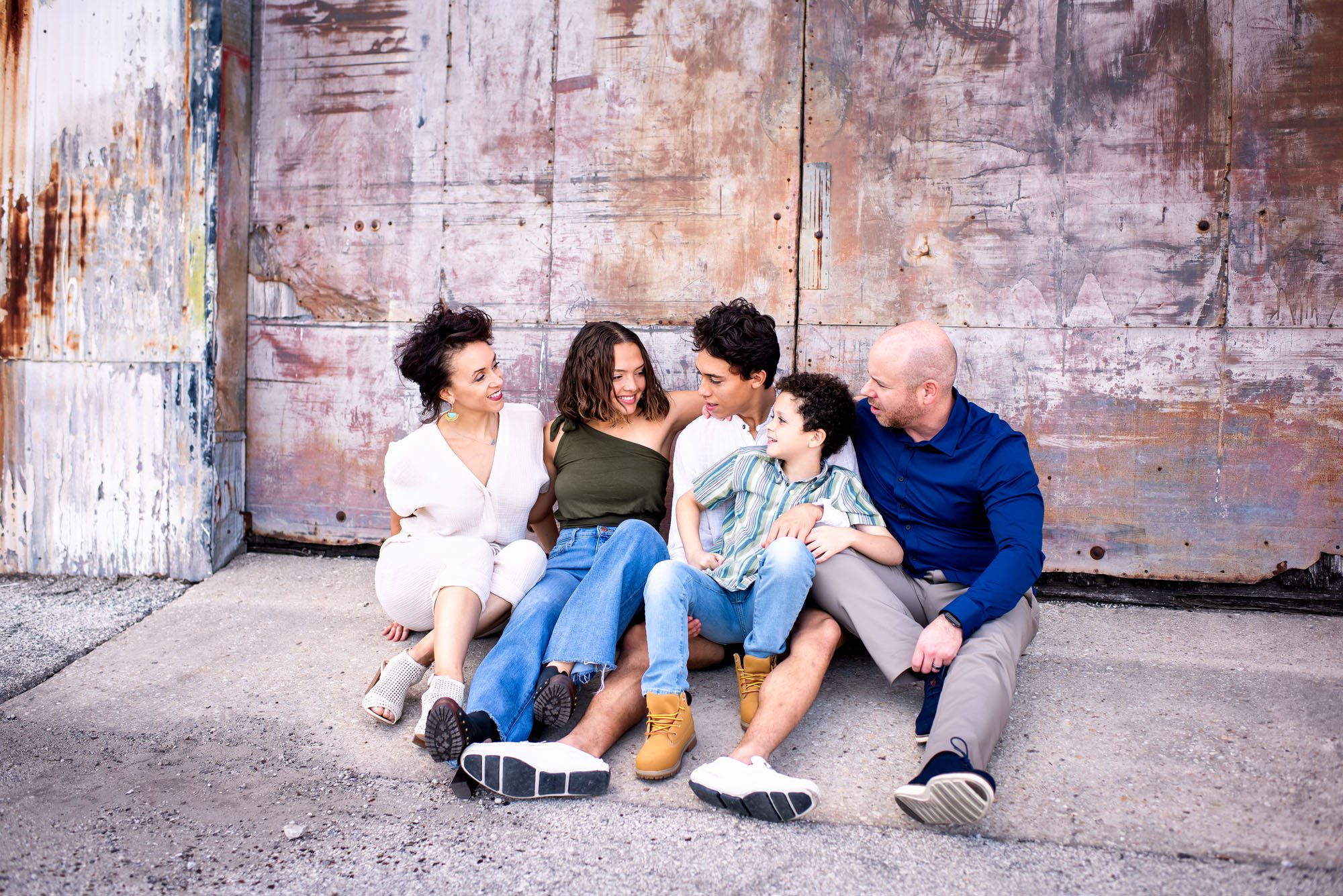 Family sitting together by colorful garage, San Antonio lifestyle photographer