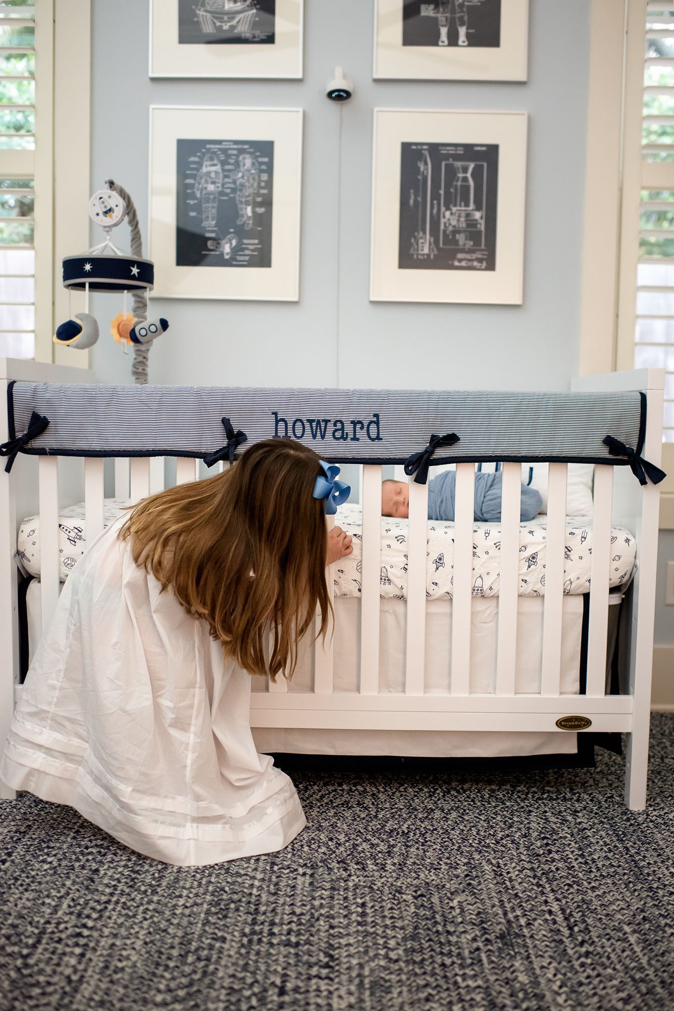 Sister peeking at newborn in crib, San Antonio newborn photographer