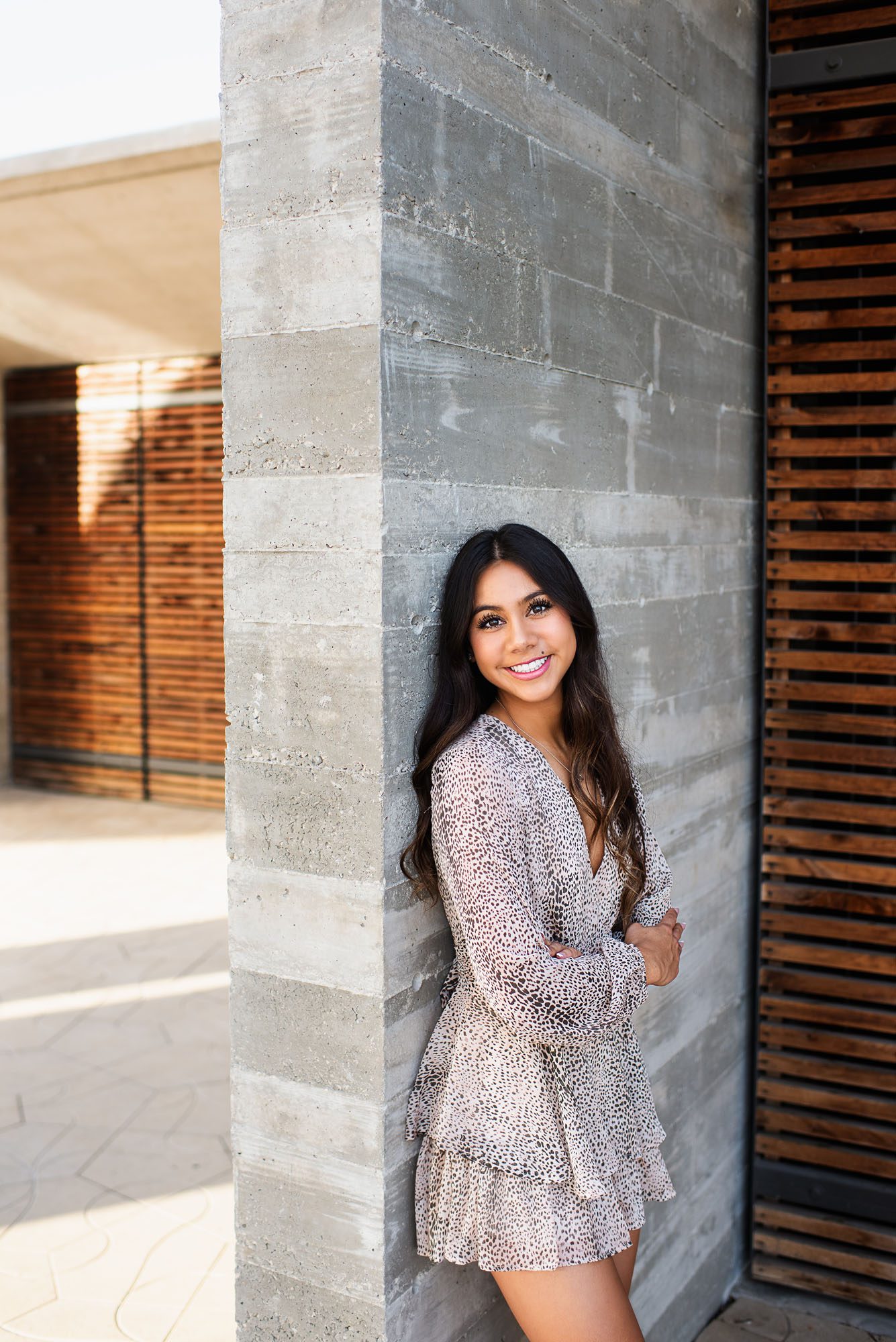 Girl standing against a cement and wood wall , Best San Antonio Senior Photographer