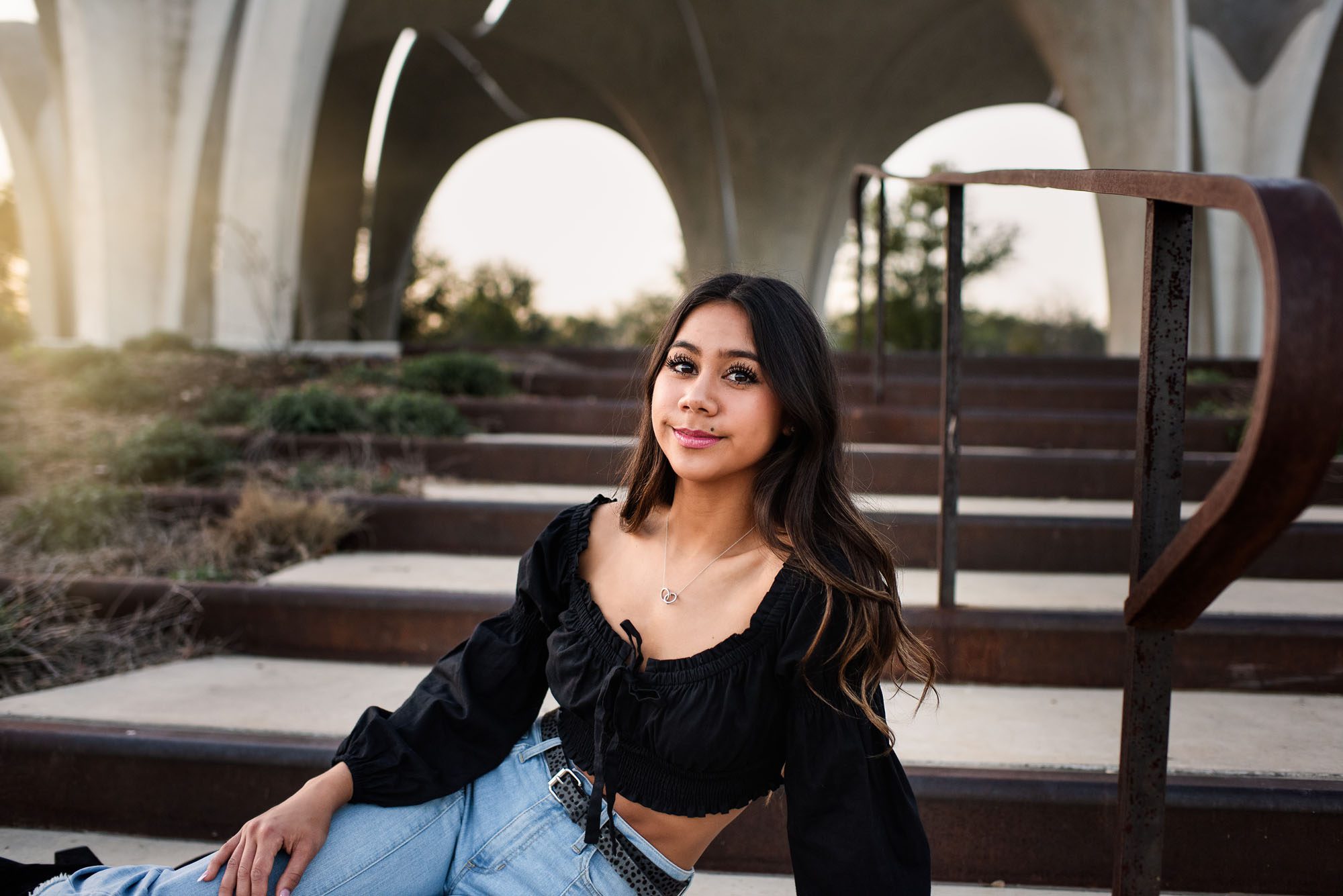 Senior sitting on stairs with arches behind her, Best Senior Photographer in San Antonio