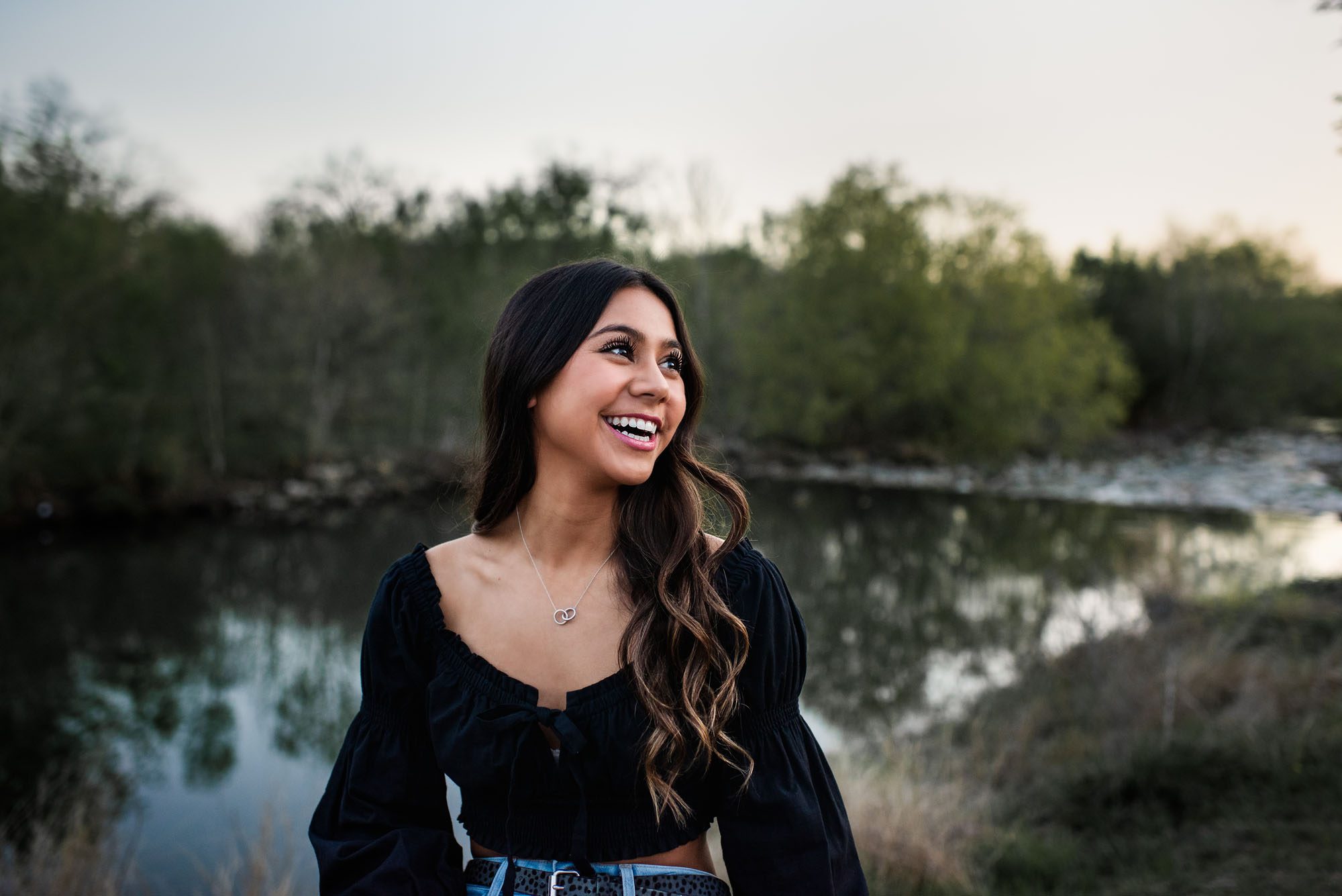 Girl smiling and sitting by the San Antonio River, Best Senior Photographer in San Antonio