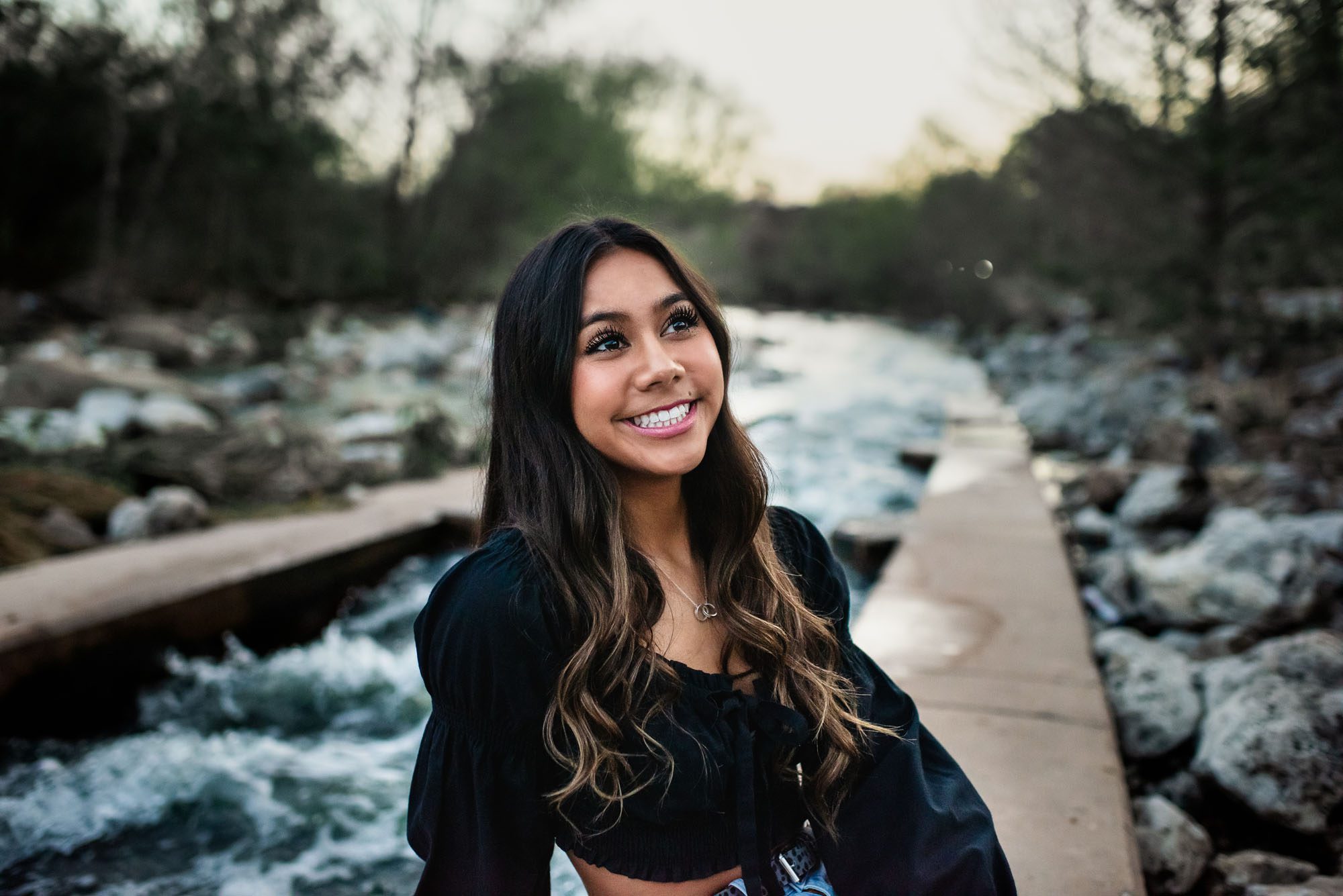 Girl smiling and sitting by the San Antonio River, Senior Portraits San Antonio