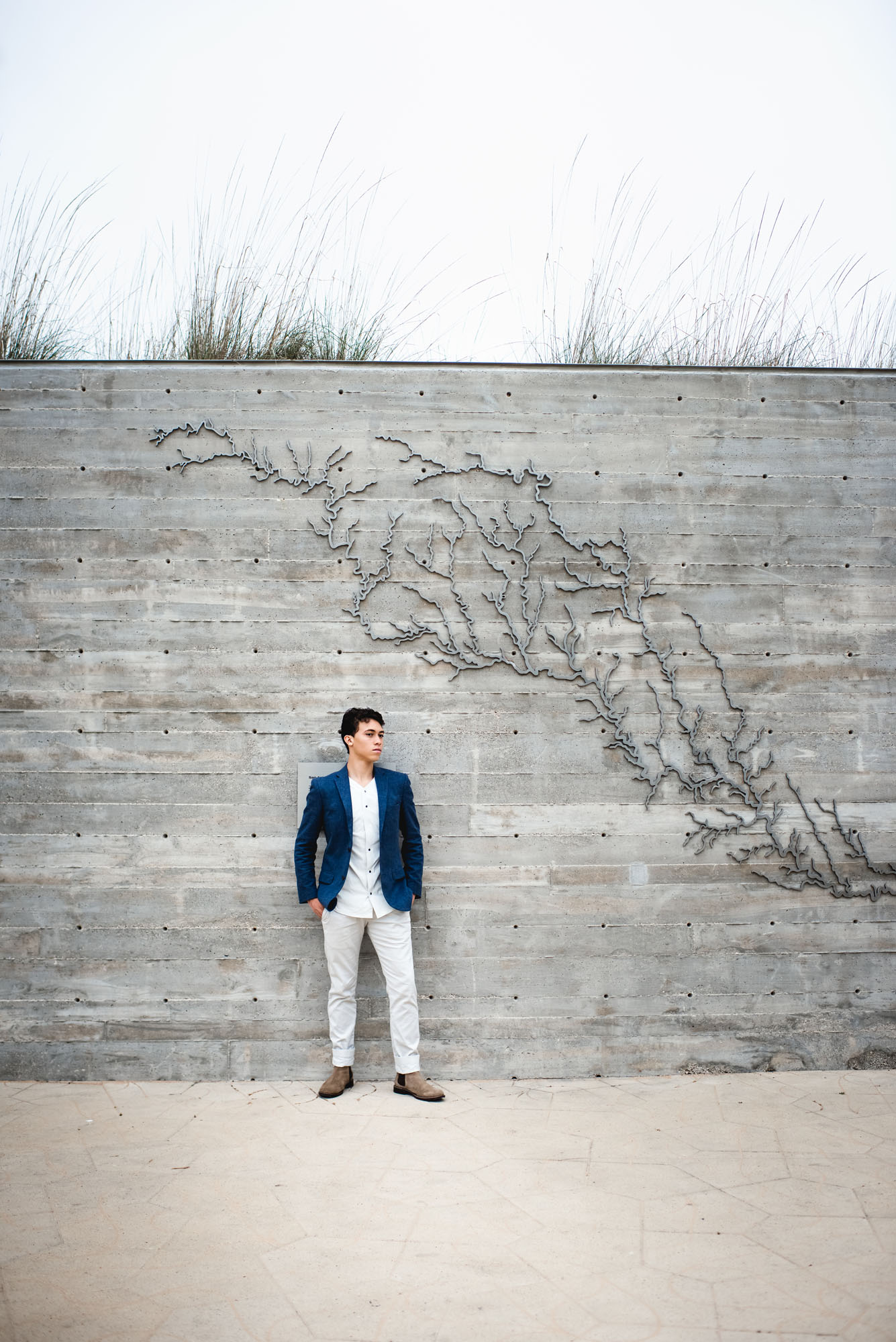Boy in blazer and pants standing by cement wall, Best San Antonio Senior Photographer
