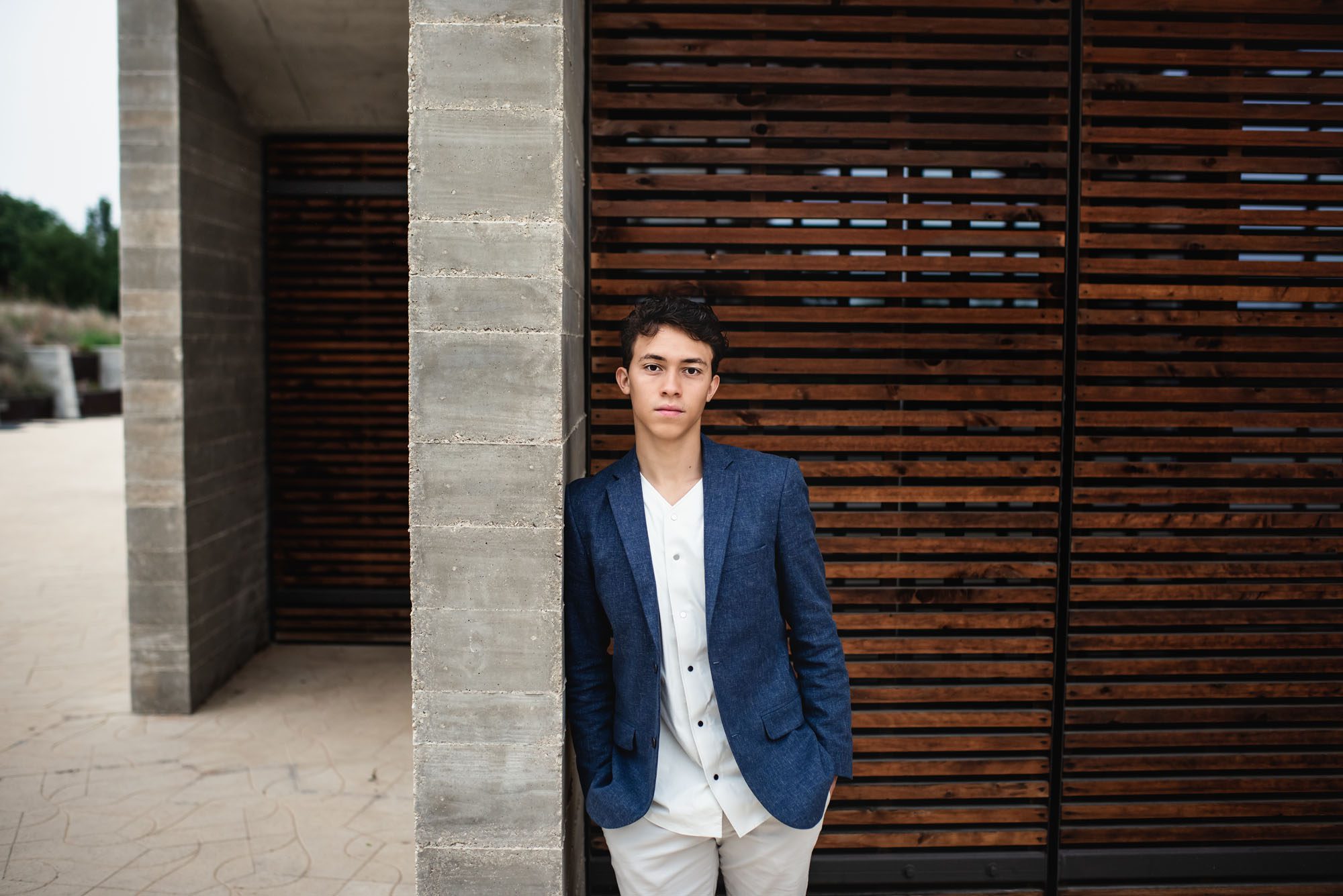 Boy leaning against cement and wood wall, San Antonio Senior Photographer
