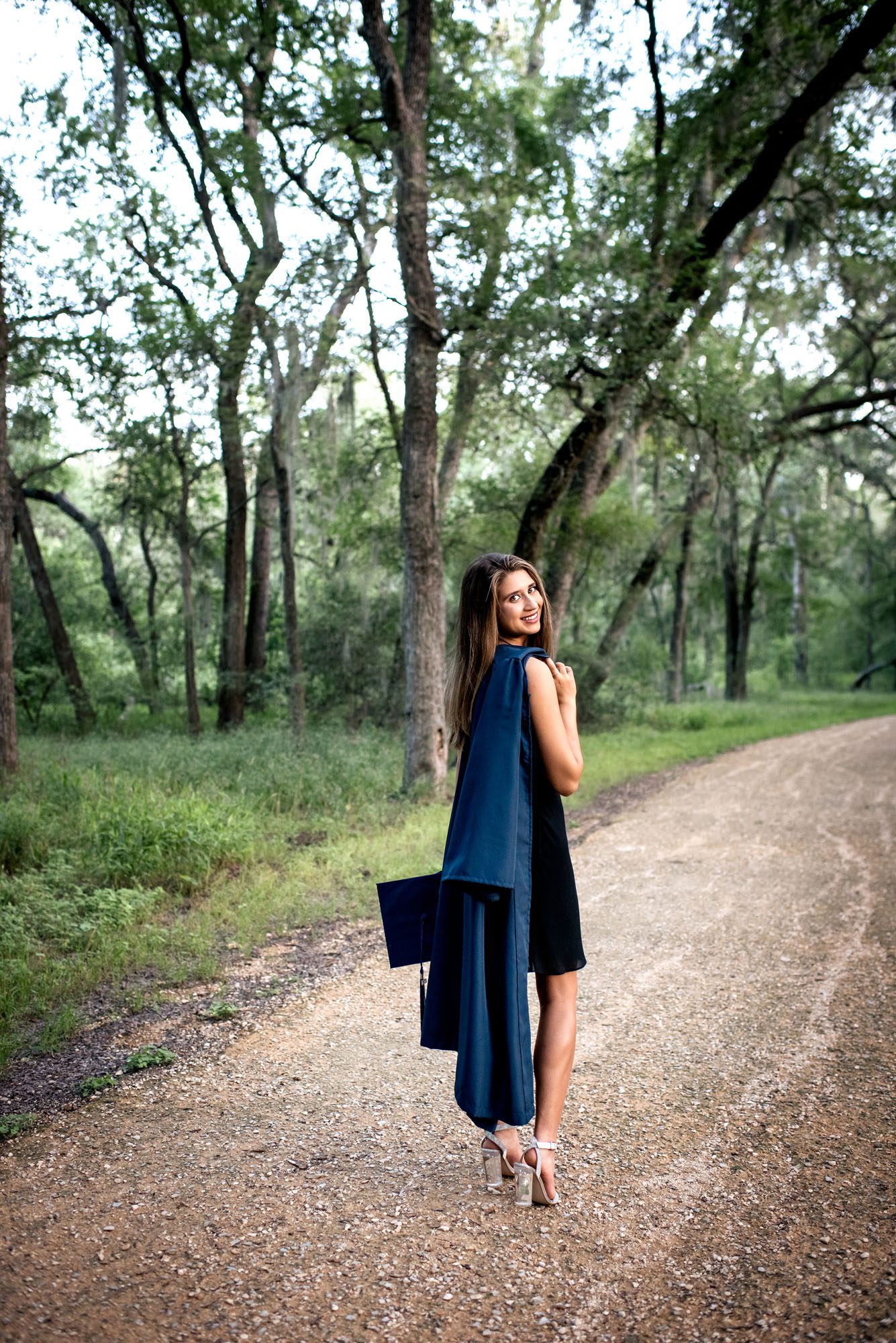 Senior girl walking away with cap and gown, San Antonio Senior Portrait Photographer