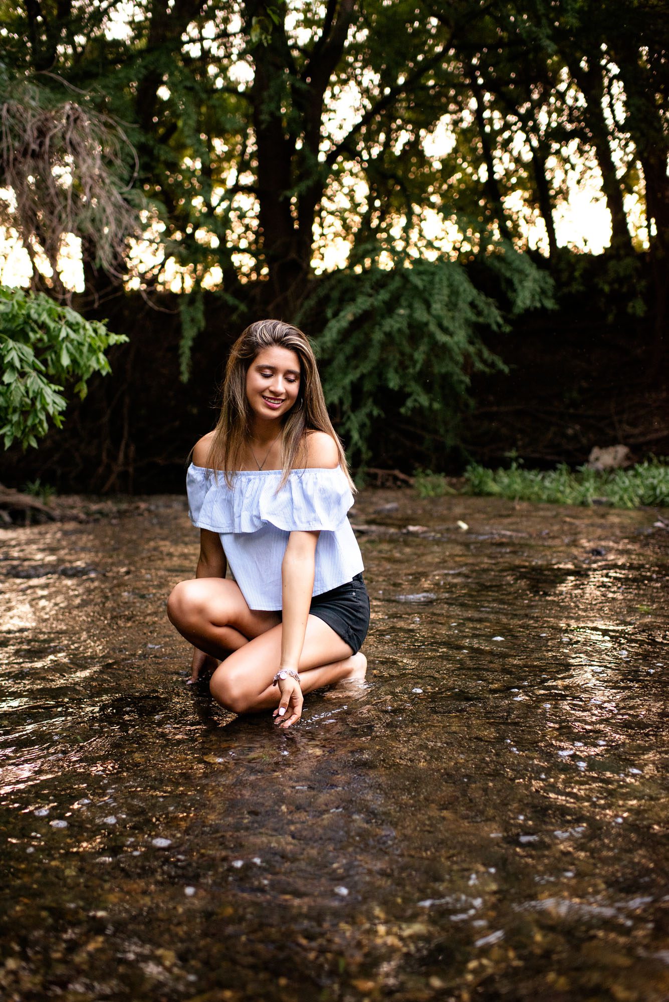 Senior girl sitting in shallow creek, Best San Antonio Senior Photographer