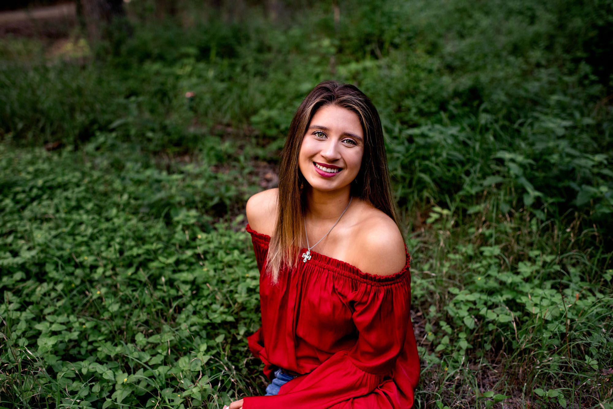 Girl in red shirt sitting in the grass, Best San Antonio Senior Photographer