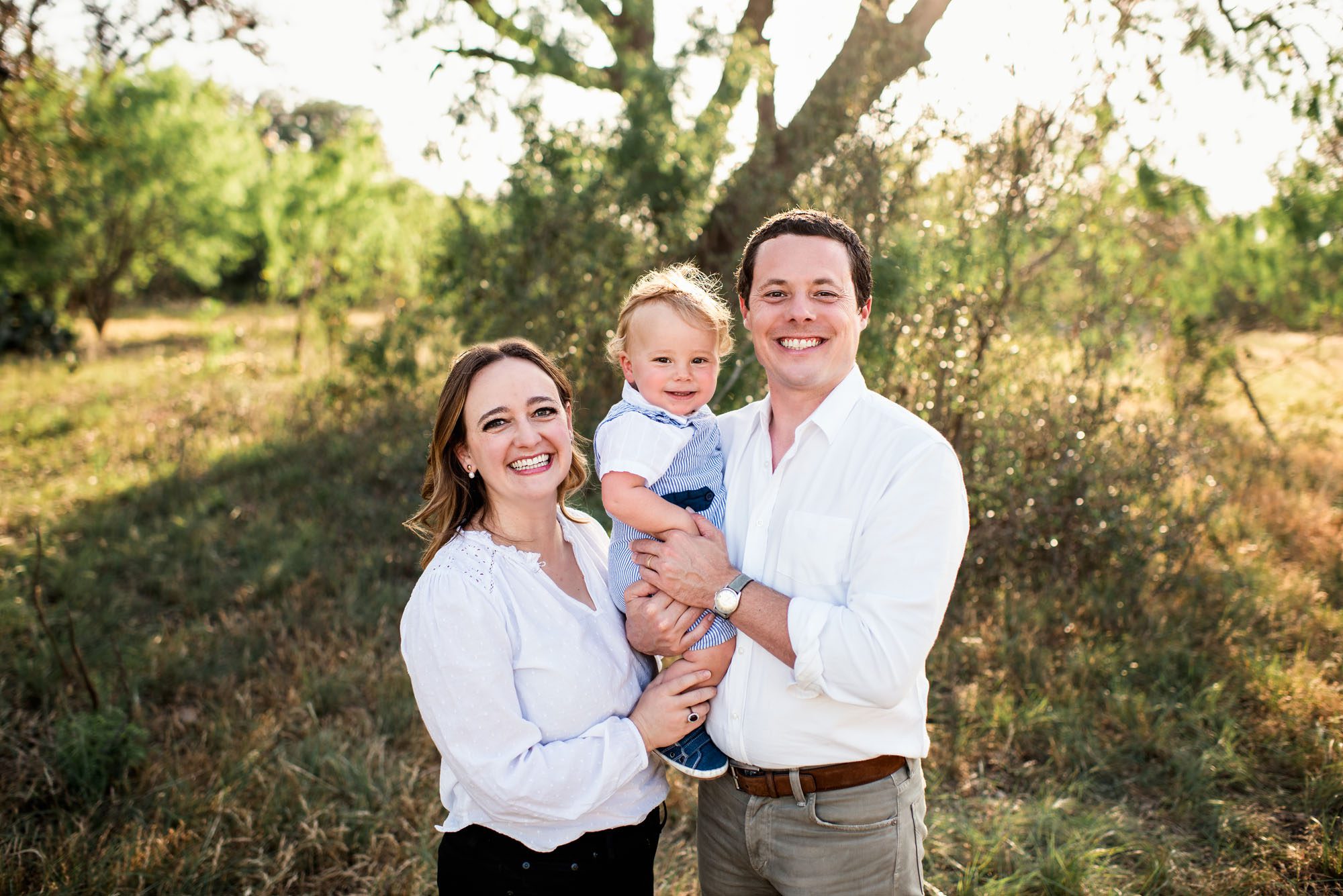 Family smiling in a field at sunset, San Antonio lifestyle photographer
