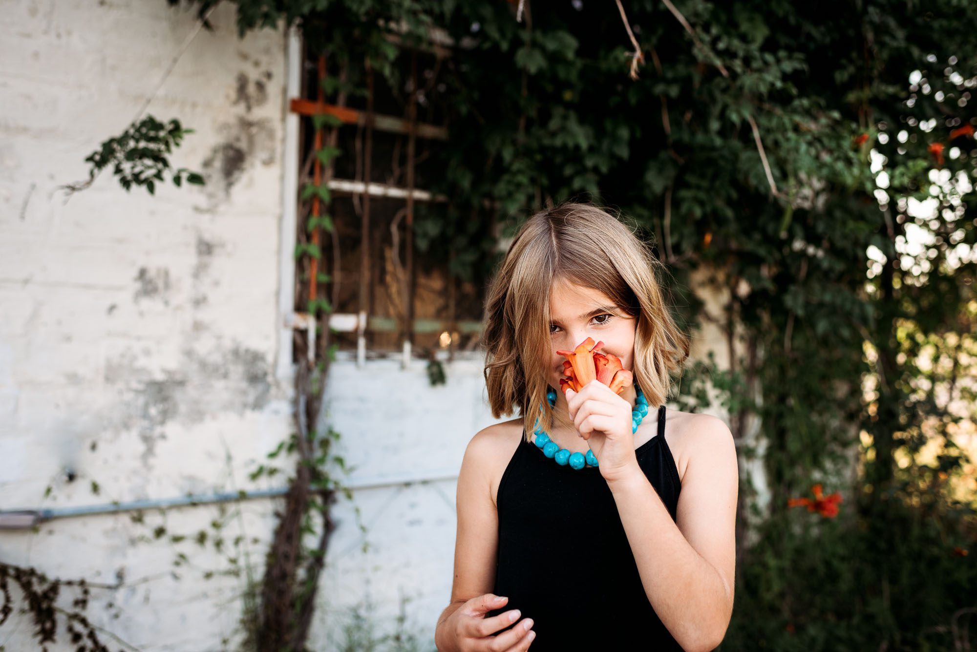 Girl smelling orange flower, San Antonio lifestyle photographer