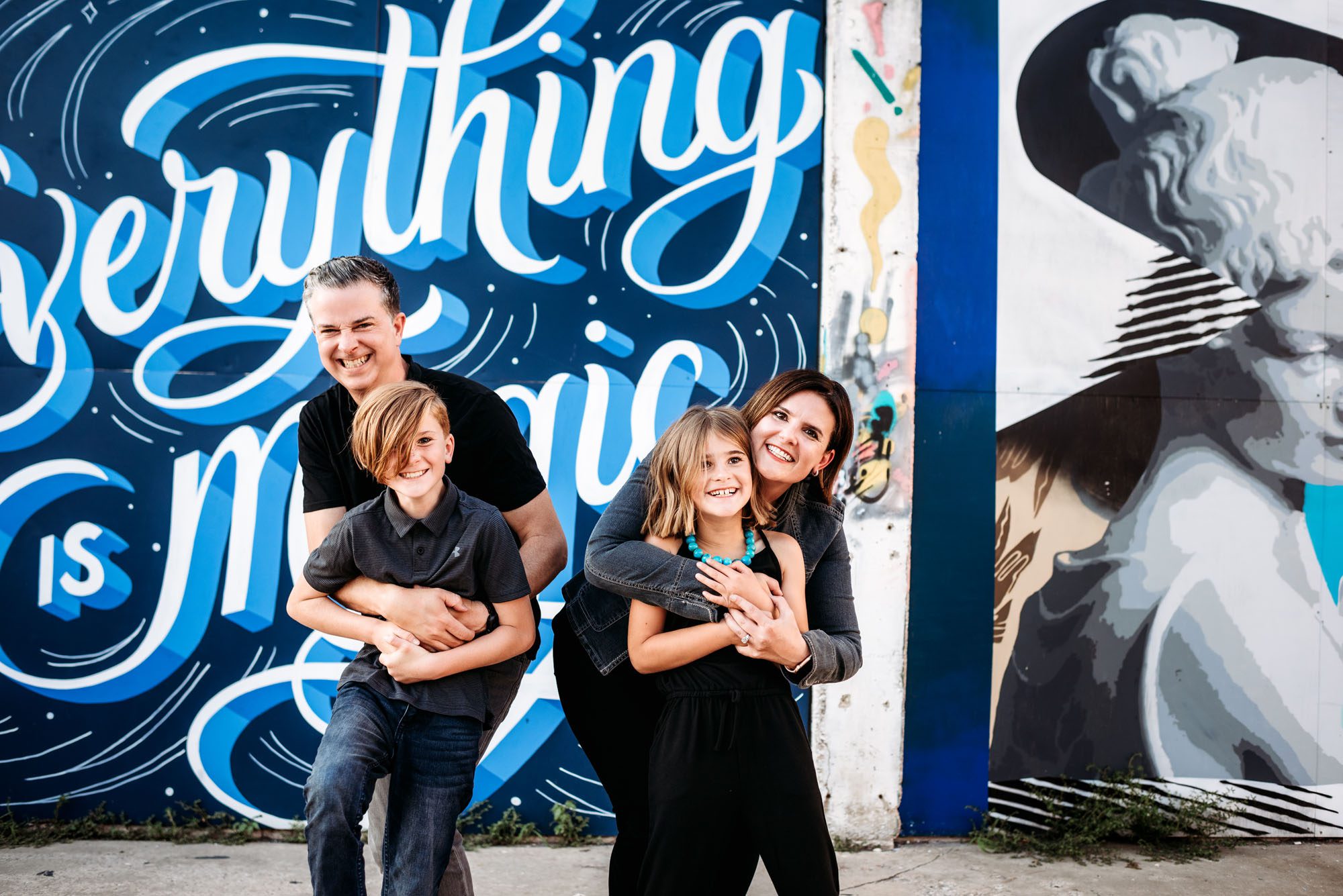 Family hugging by art mural, San Antonio lifestyle photographer