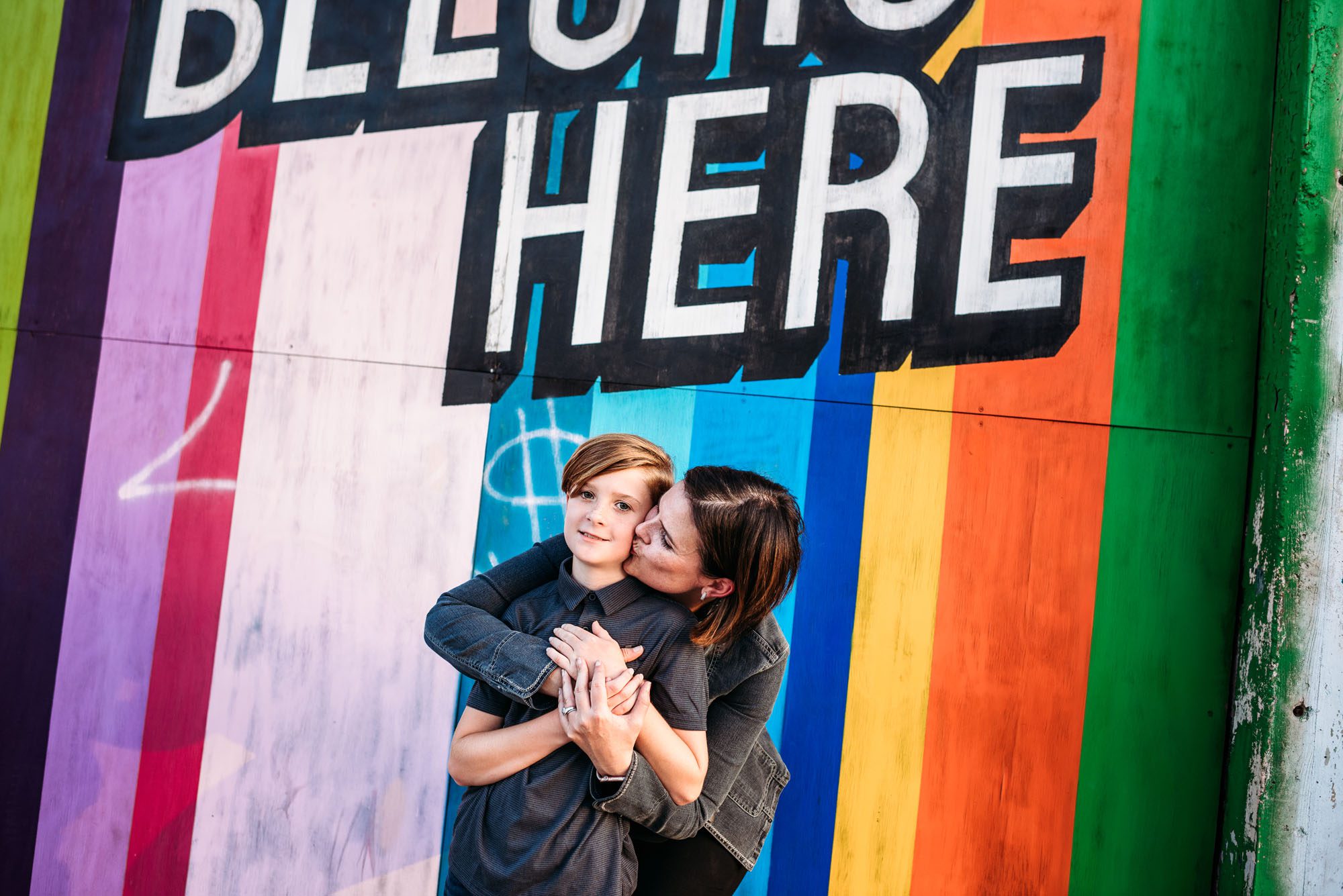 Mom kissing son by colorful wall, San Antonio family photographer