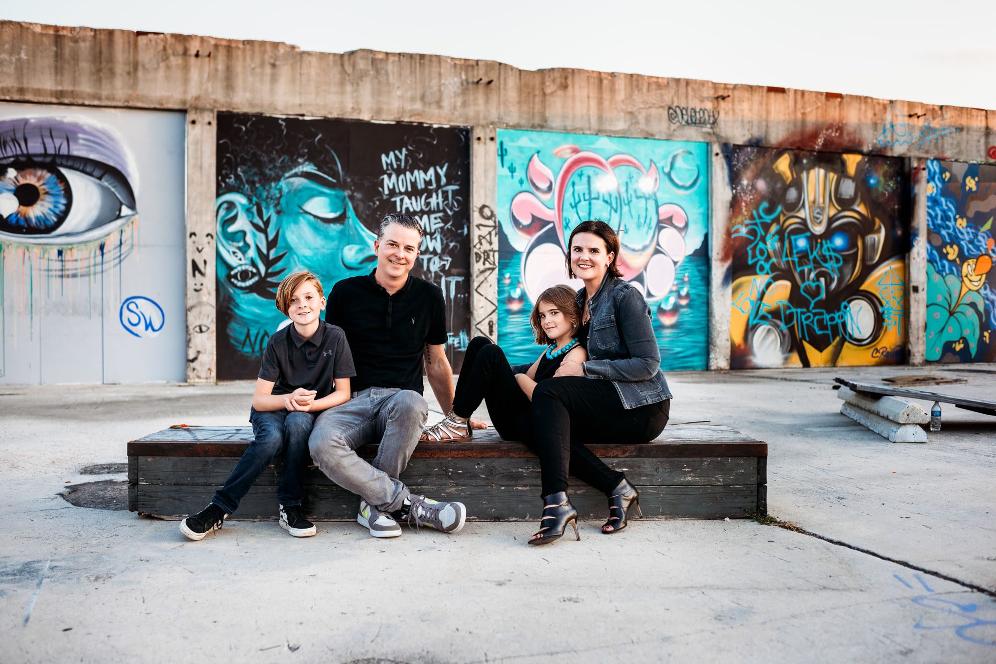 Family sitting by art mural, Lifestyle photographer in San Antonio