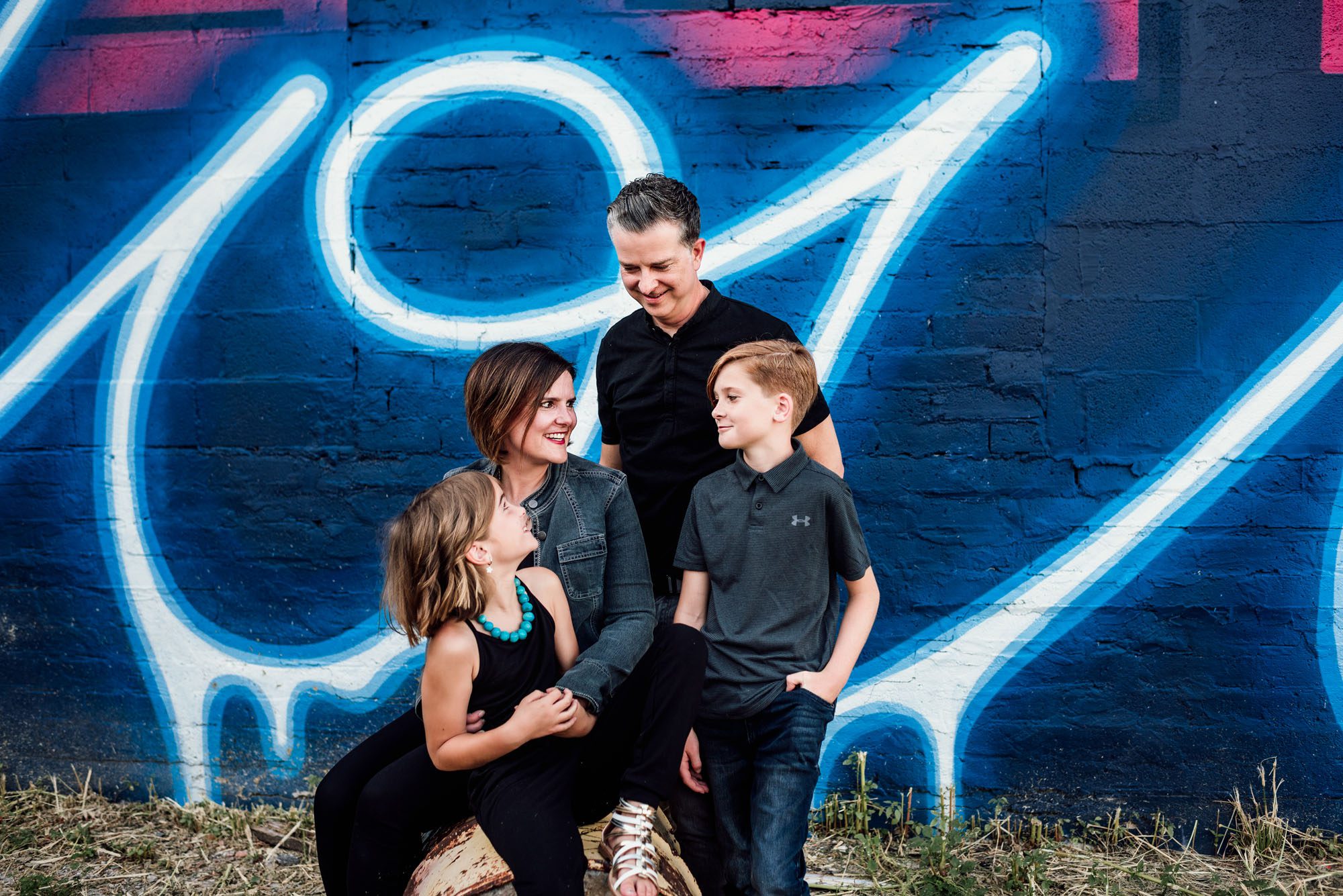 Family sitting by art mural, San Antonio lifestyle photographer