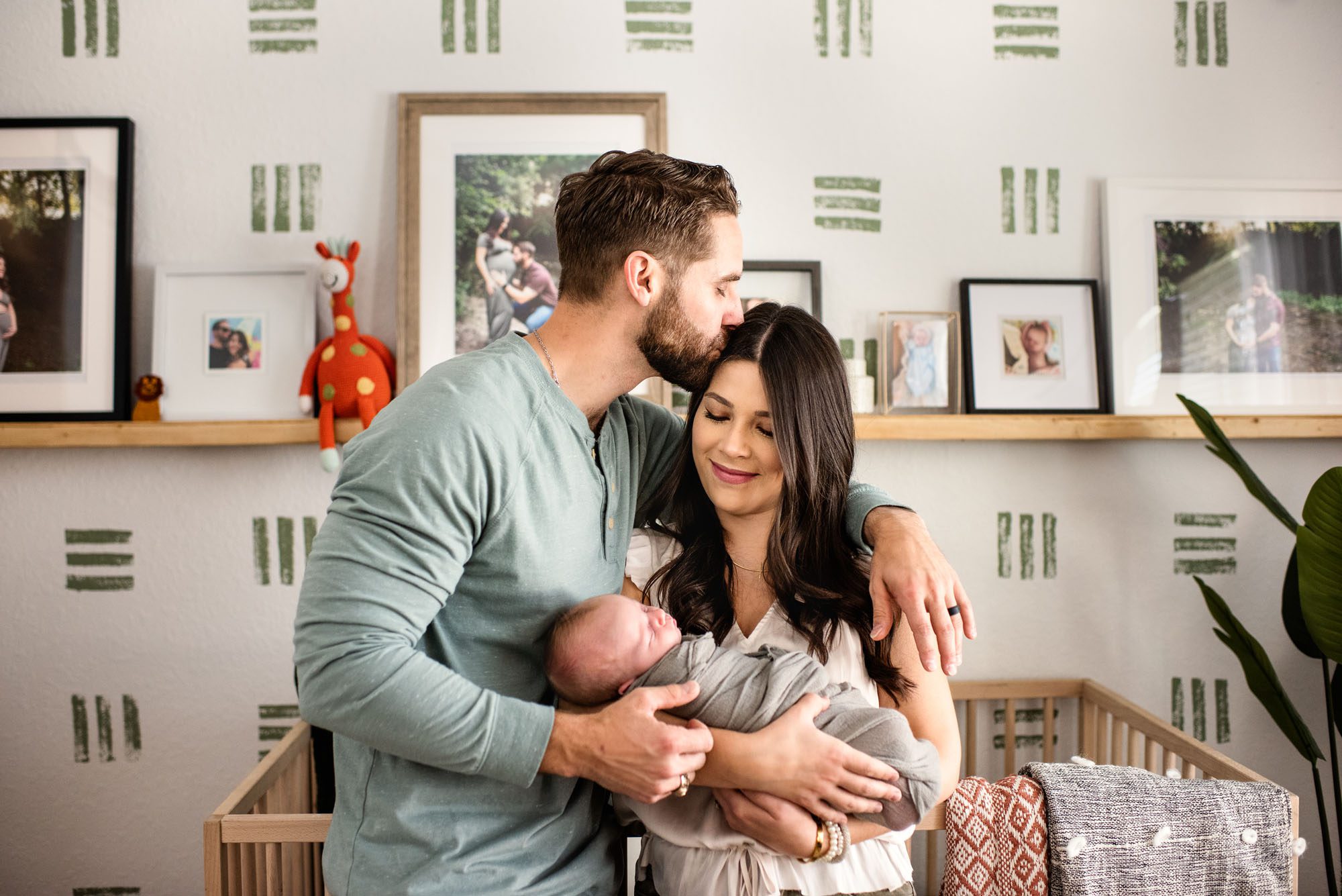 San Antonio Newborn Photographer, Couple holding newborn while dad kisses mom on the forehead