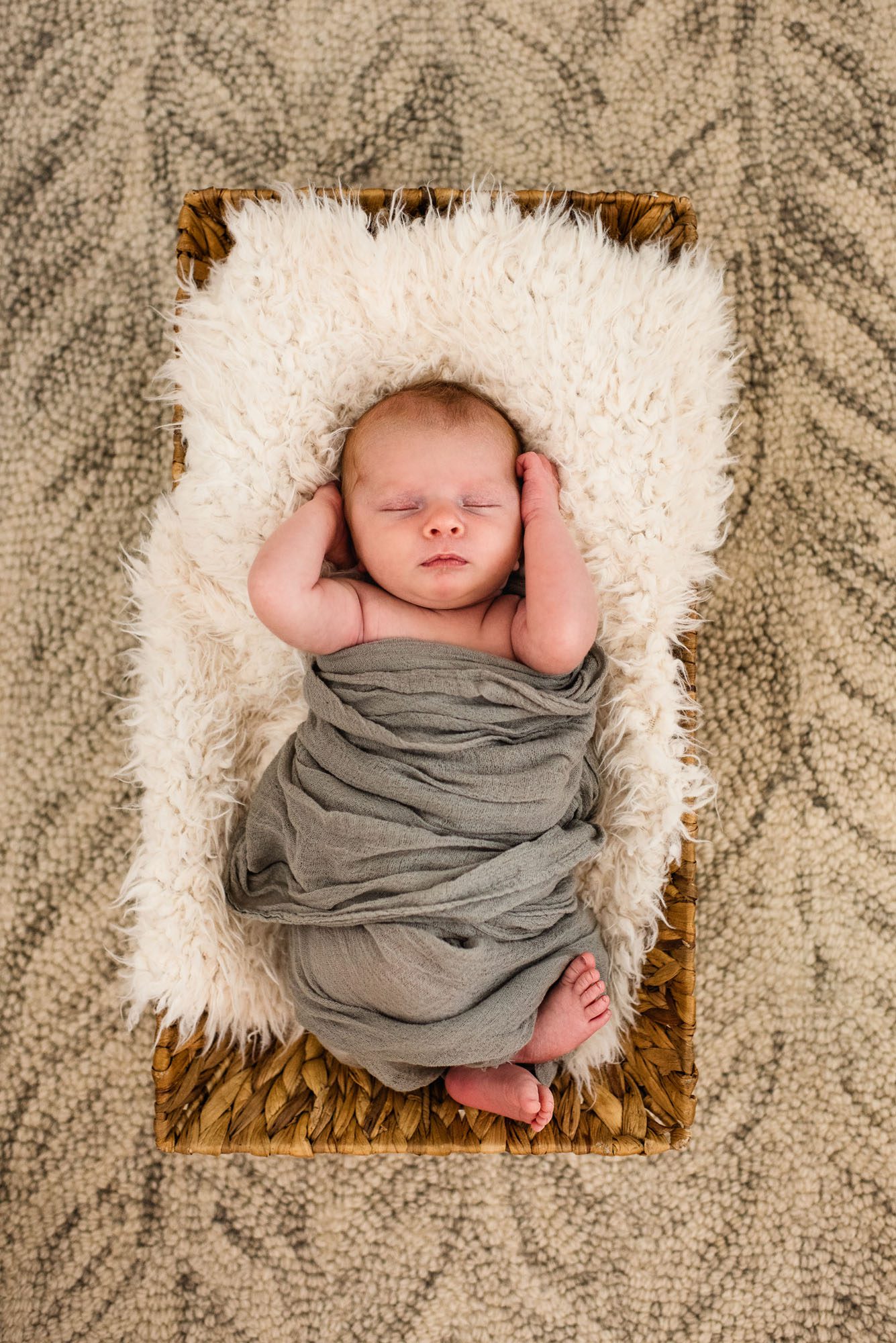 San Antonio Newborn Photographer, Newborn baby asleep in basket with hands up by his ears