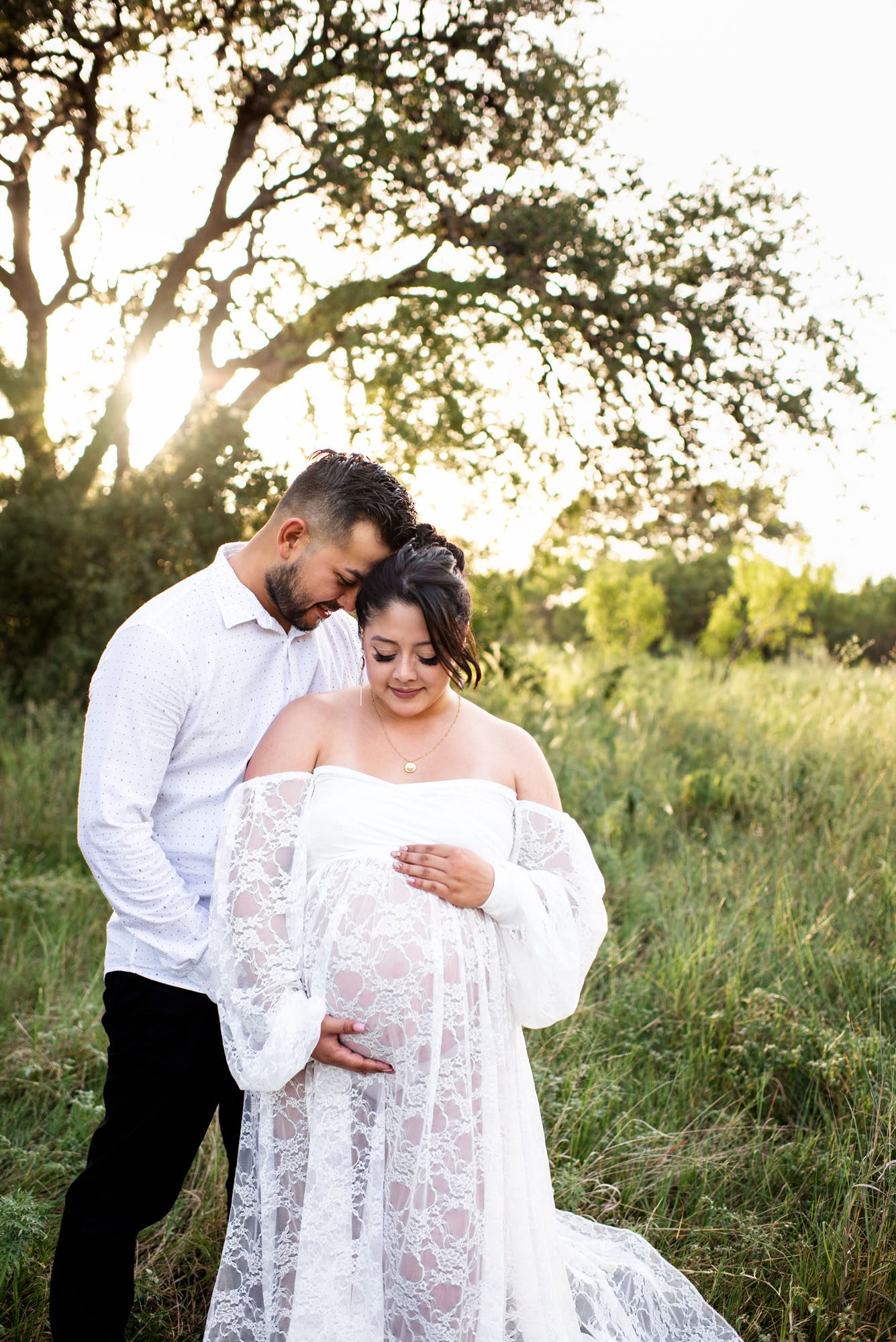 Expectant couple looking down at baby bump, San Antonio maternity photographer