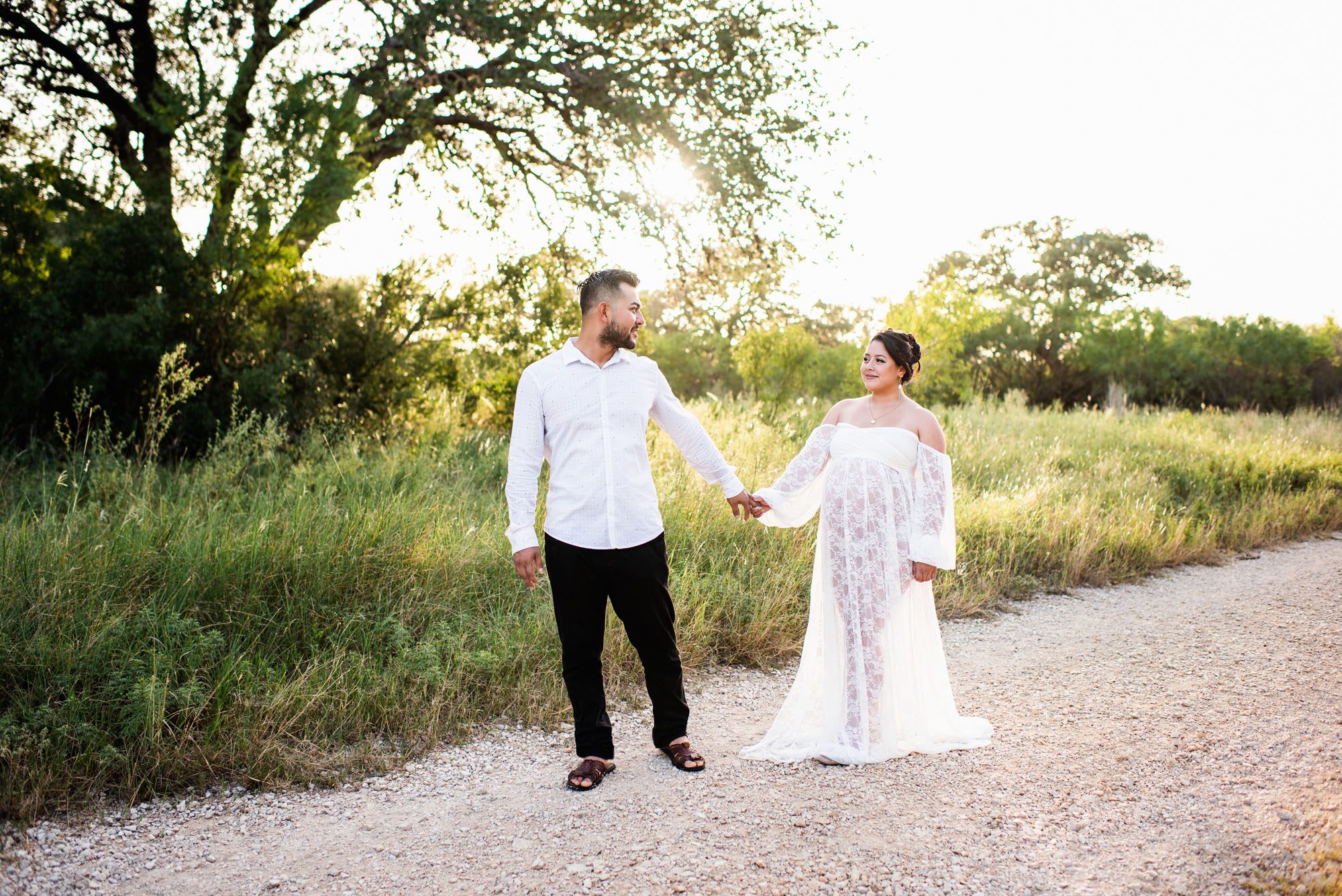 Expectant couple walking together near a field, San Antonio maternity lifestyle session