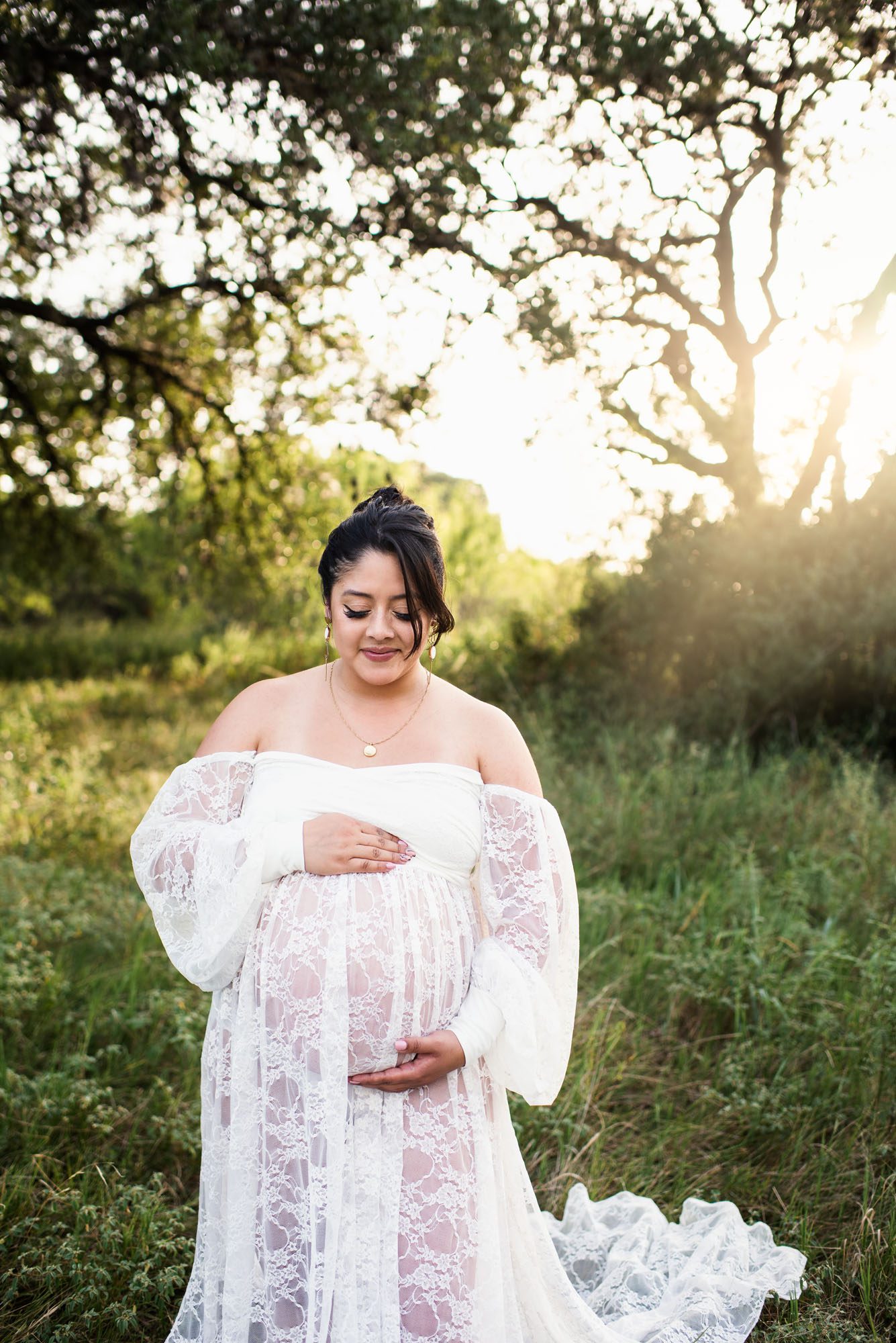 San Antonio Maternity Photographer, Pregnant woman in white lace dress looking at her belly