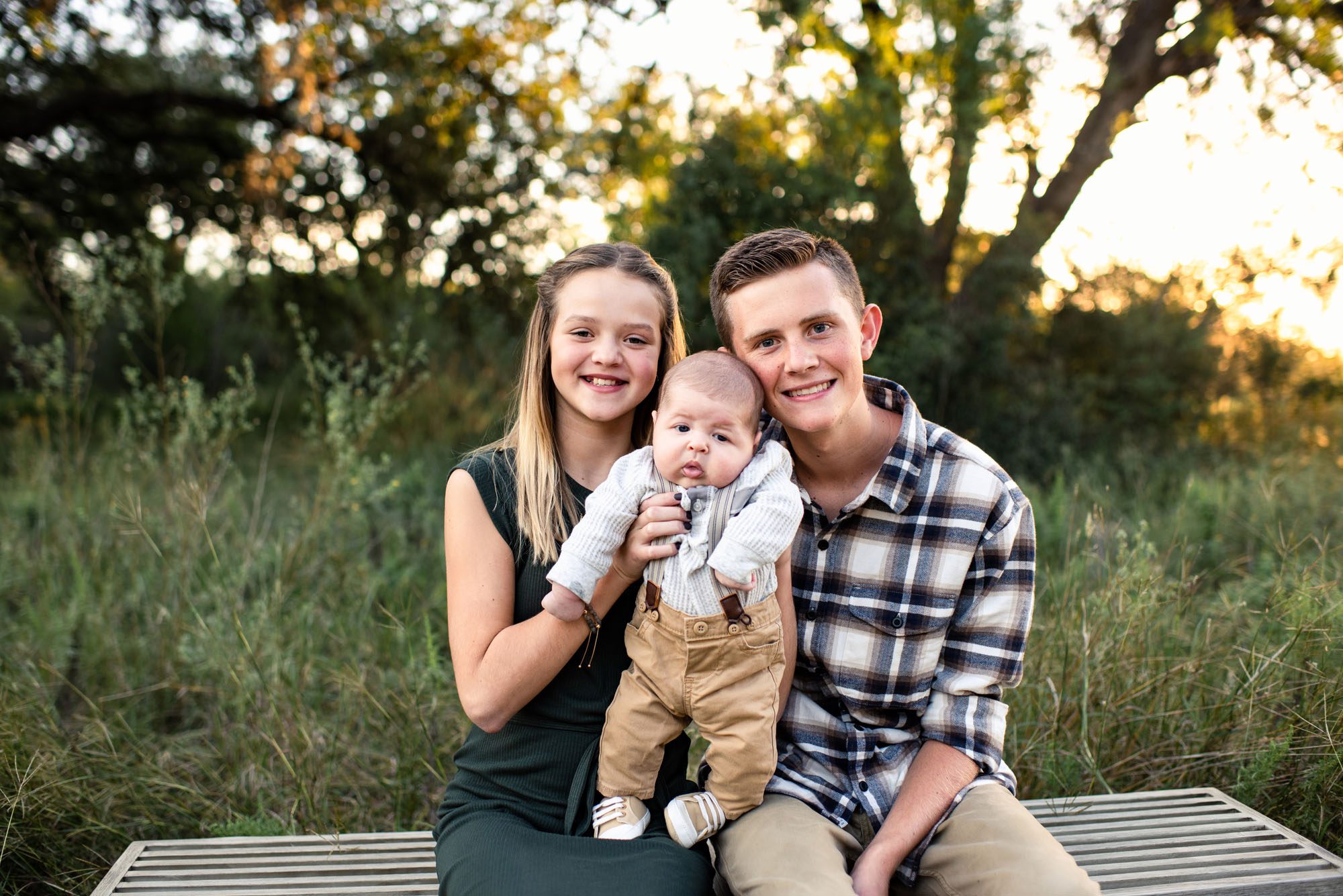 Older sister and brother holding newborn baby boy, San Antonio Family Photographer