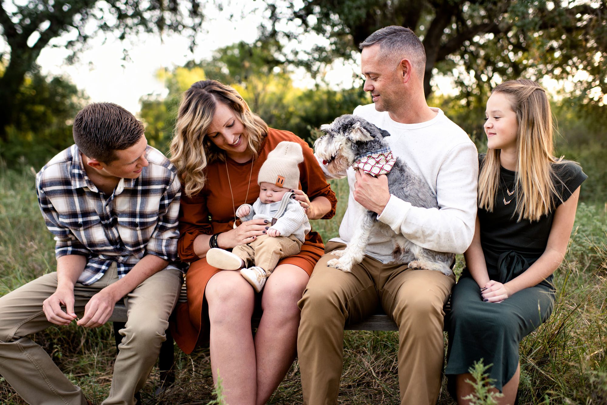 Family sitting on bench together with baby and dog, Best San Antonio Family Photographer