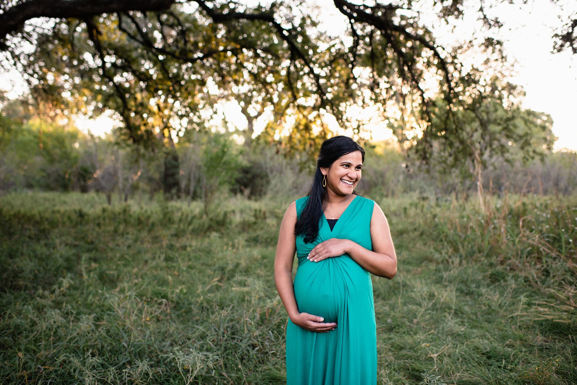 Pregnant woman smiling in green dress, Best San Antonio Maternity Photography