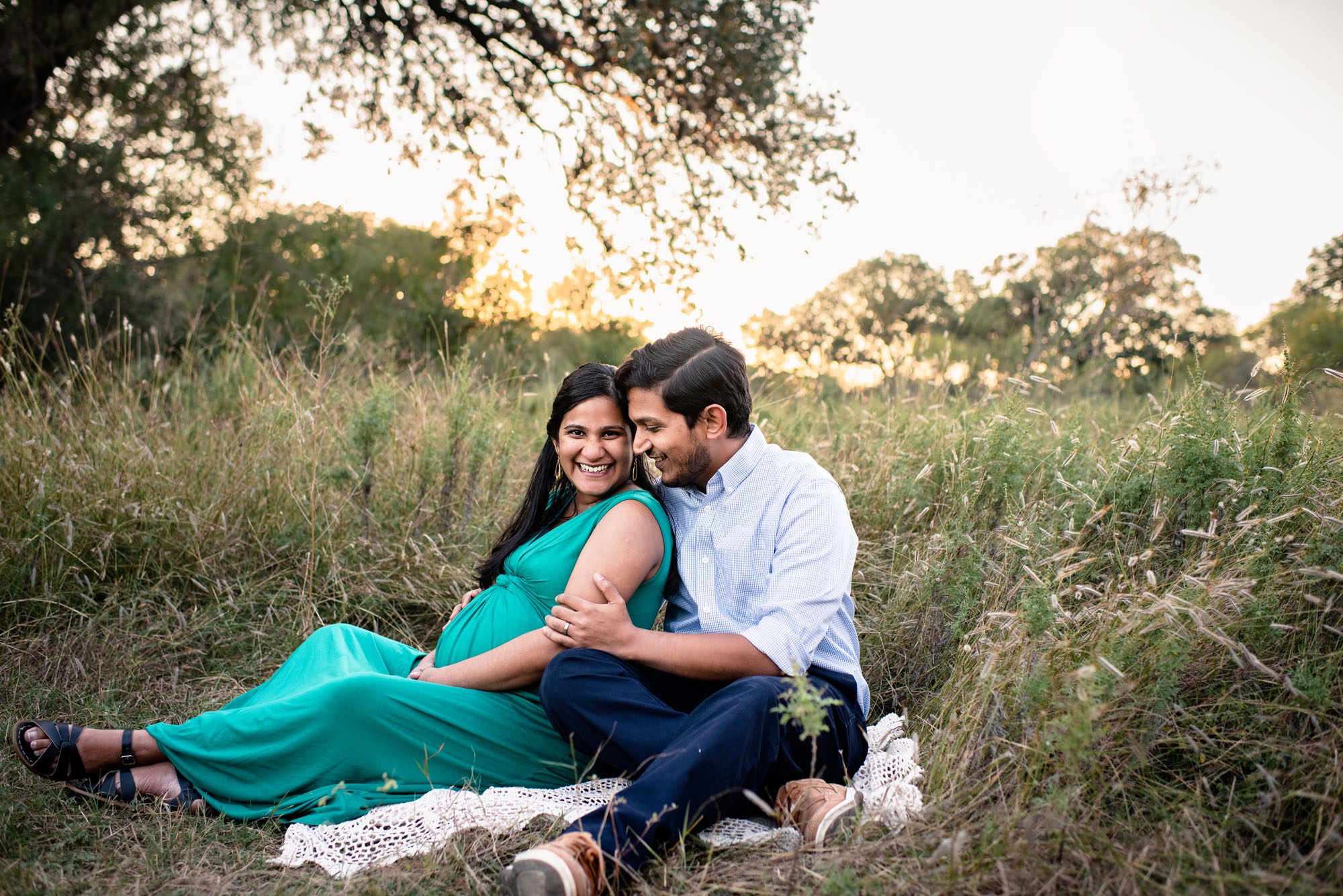 Pregnant mother and father sitting in a field, Best San Antonio Maternity Photographer