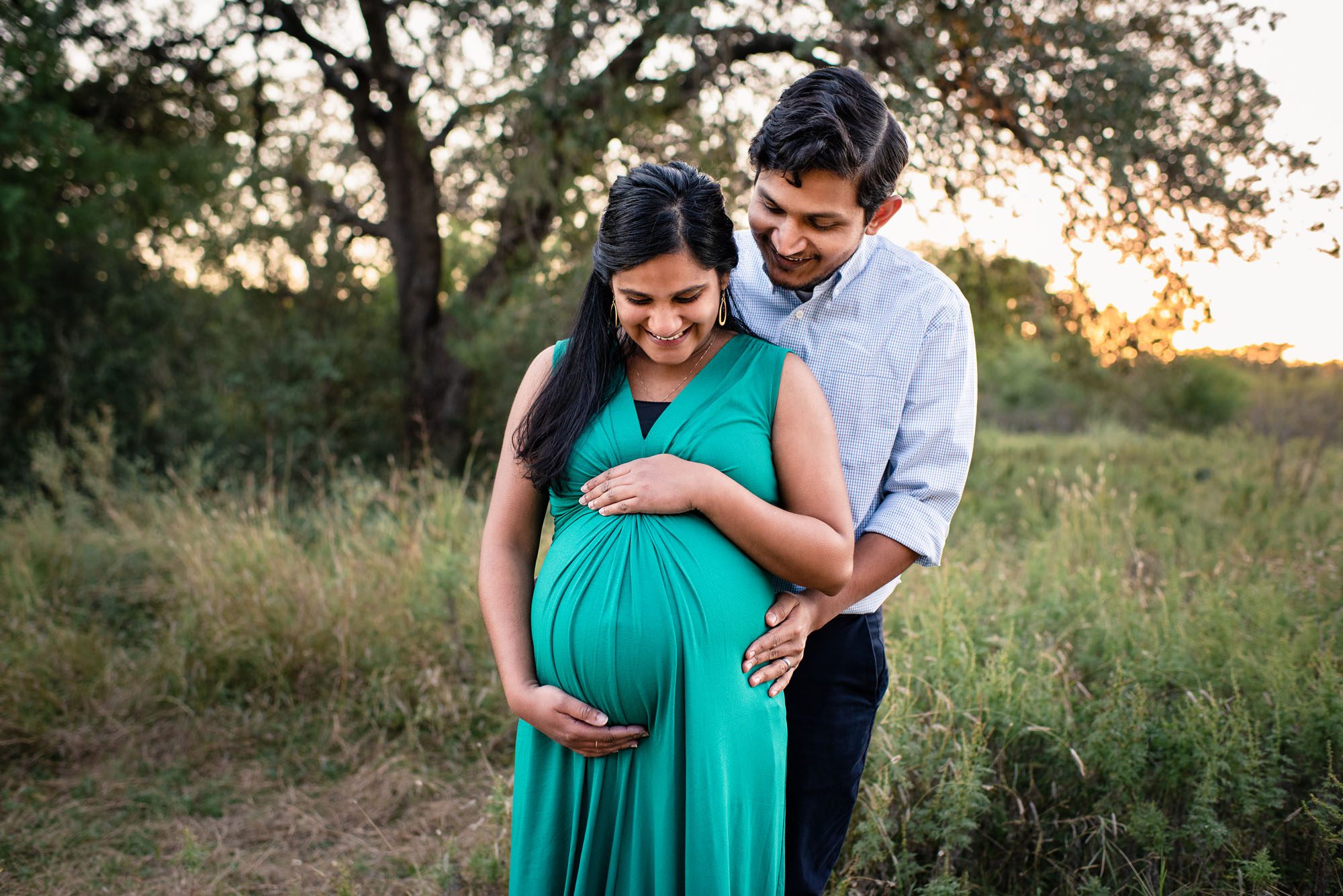Pregnant couple looking at baby bump, San Antonio Maternity Photographer