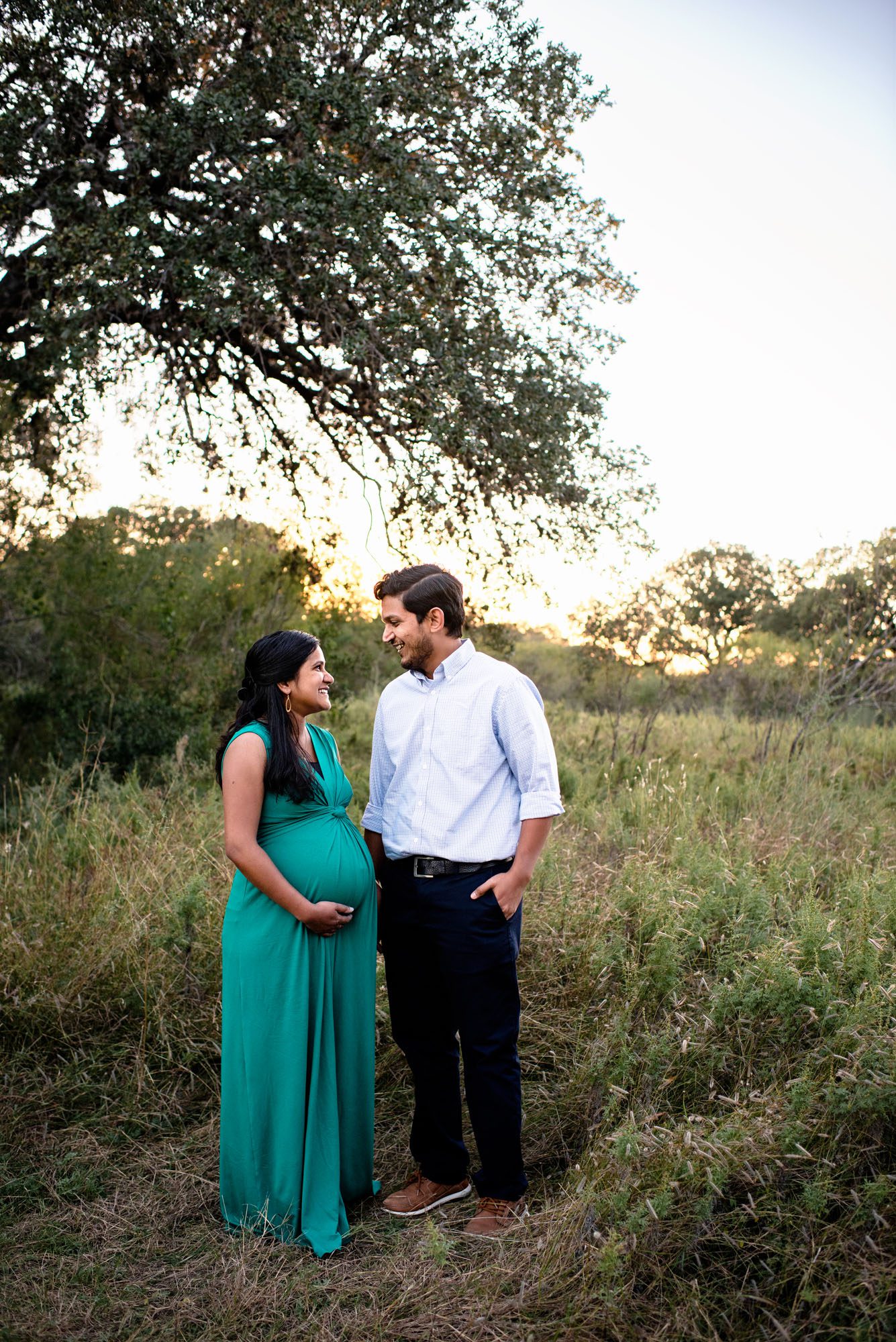 San Antonio Maternity Photographer, Pregnant couple smiling at each other in the park