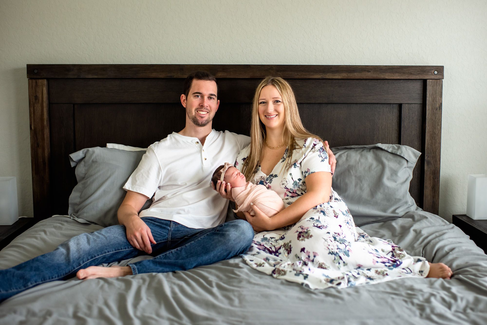 Couple on bed holding baby, San Antonio Newborn Photographer