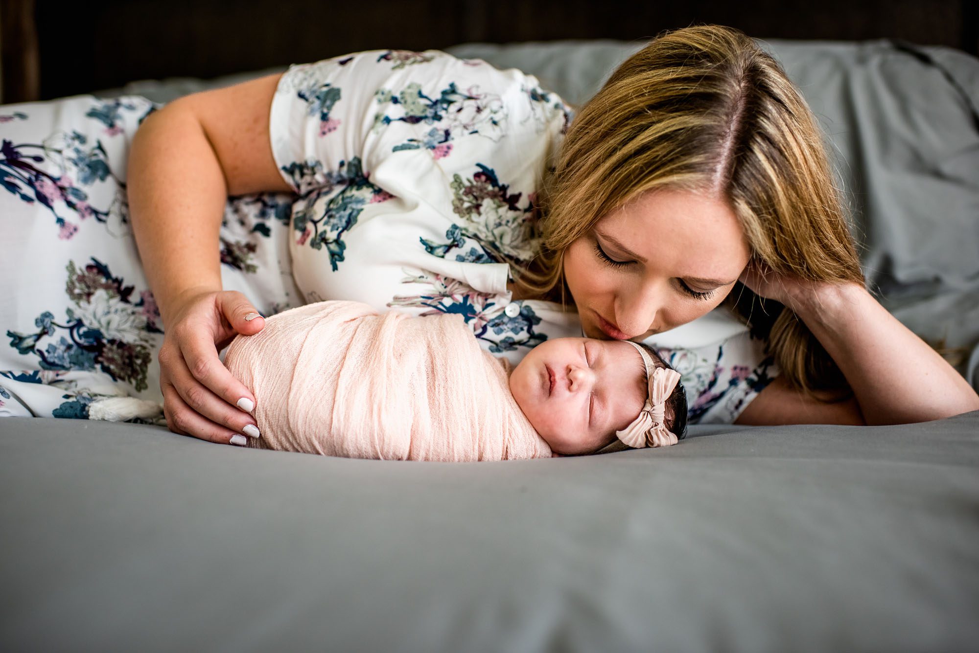 Mother on bed with newborn baby, San Antonio Newborn Photographer