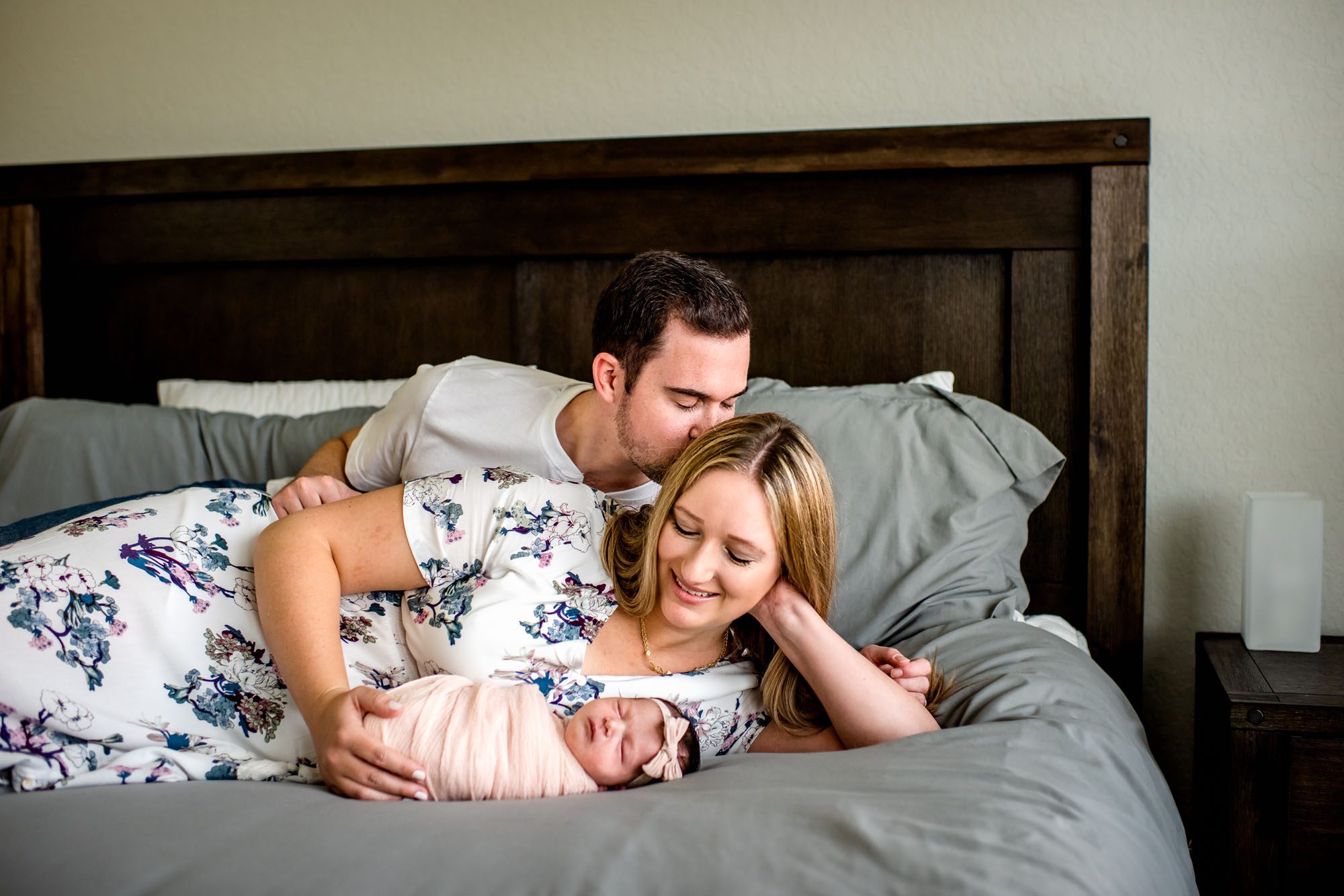 Couple on bed with newborn baby, Best Newborn Photographer