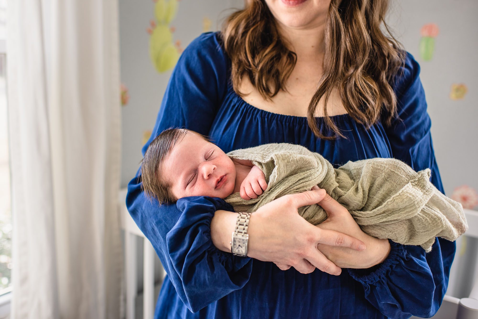 San Antonio Newborn Photographer, Mom holding newborn baby in nursery