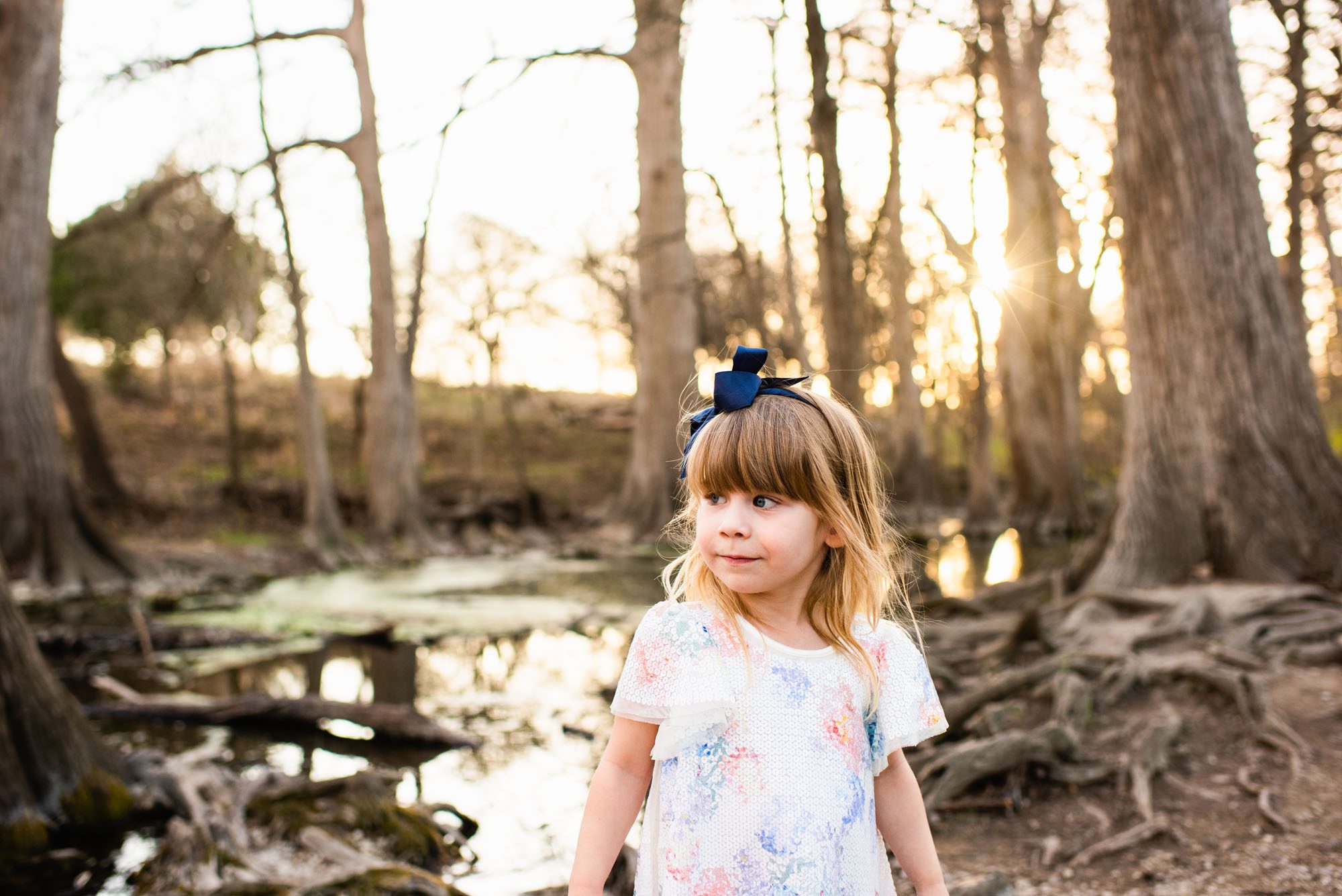 Young girl standing by river at sunset, San Antonio family lifestyle photographer