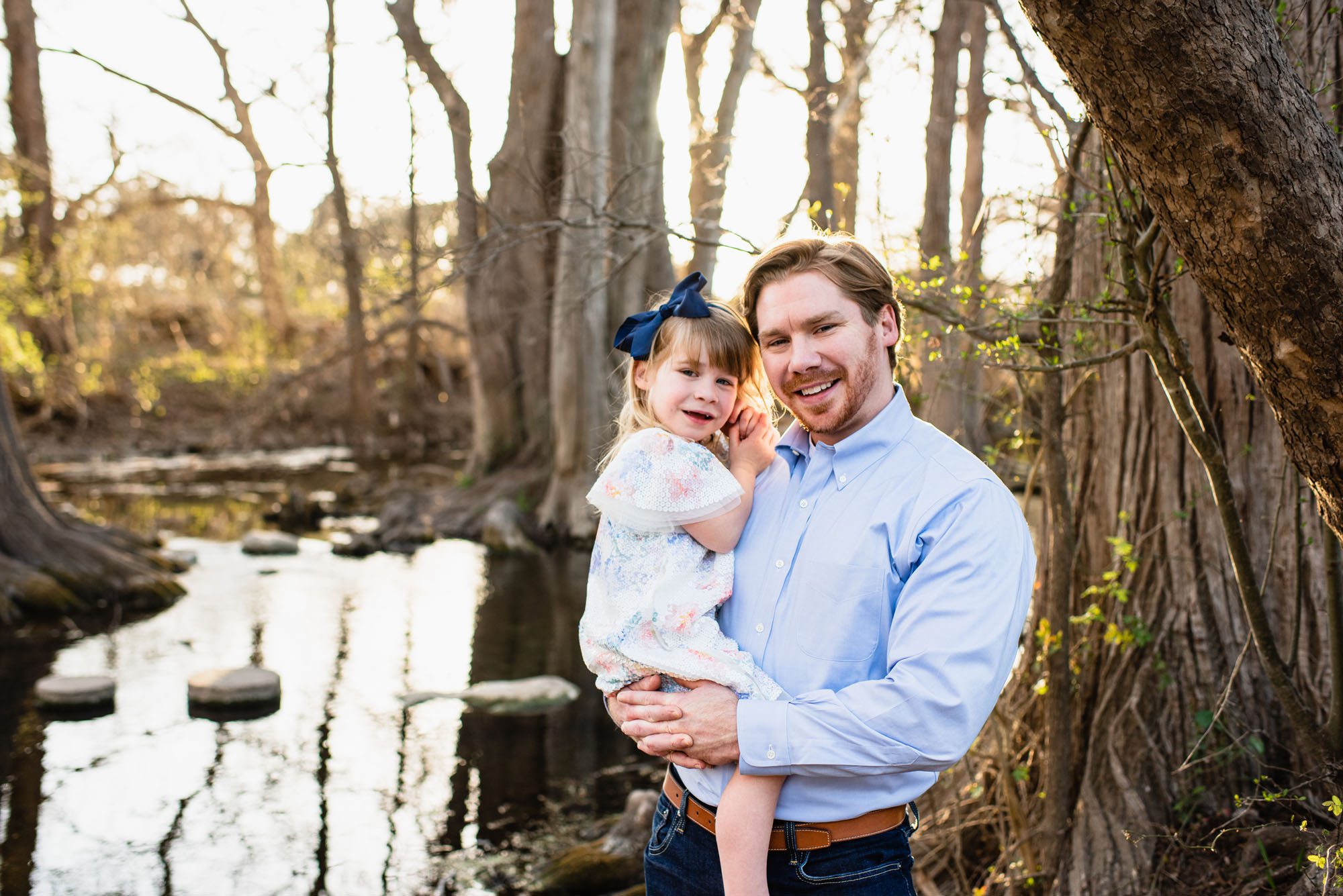 Father holding daughter by the river, San Antonio family lifestyle photographer