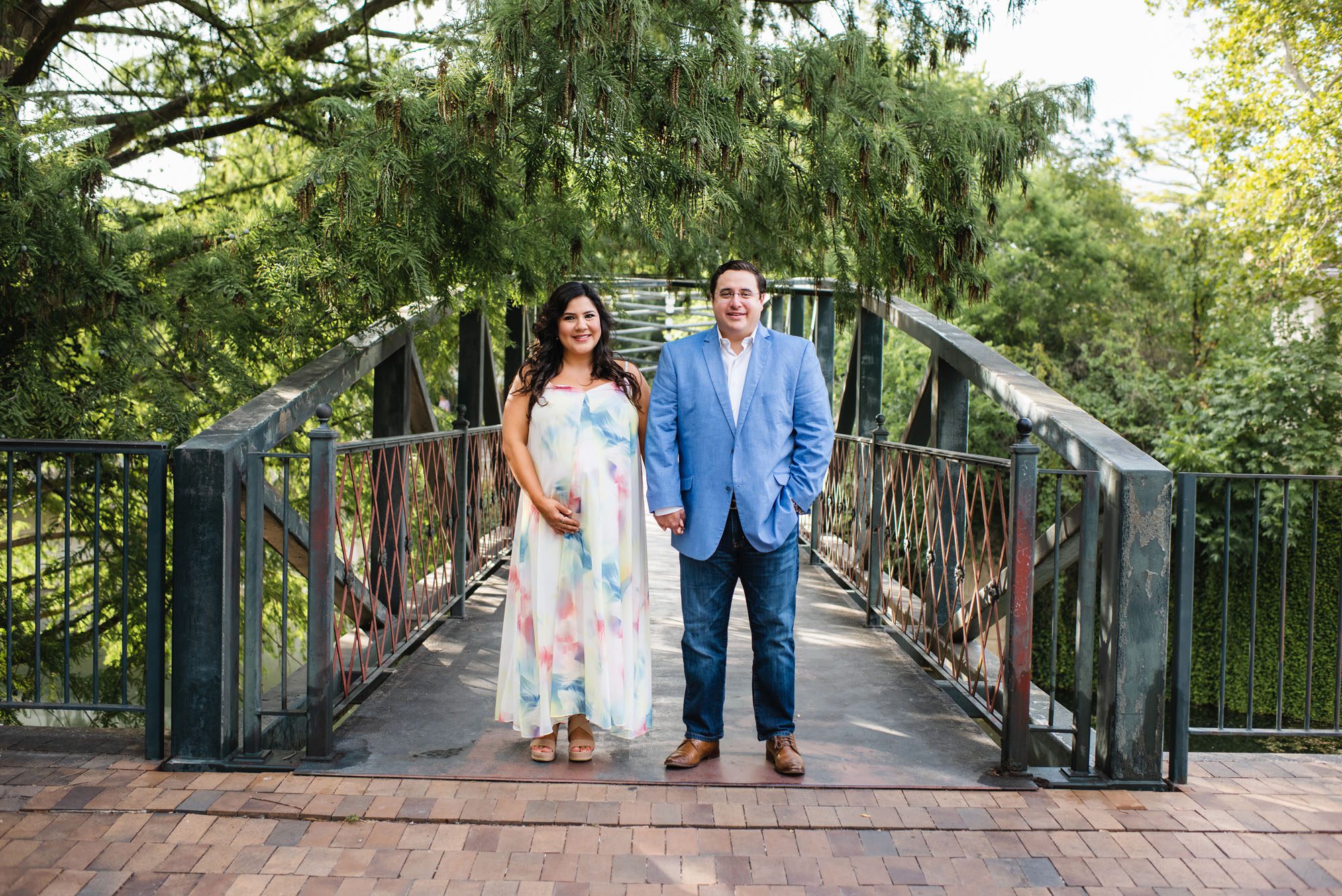 Pregnant couple holding hands on bridge, San Antonio Maternity Photographer