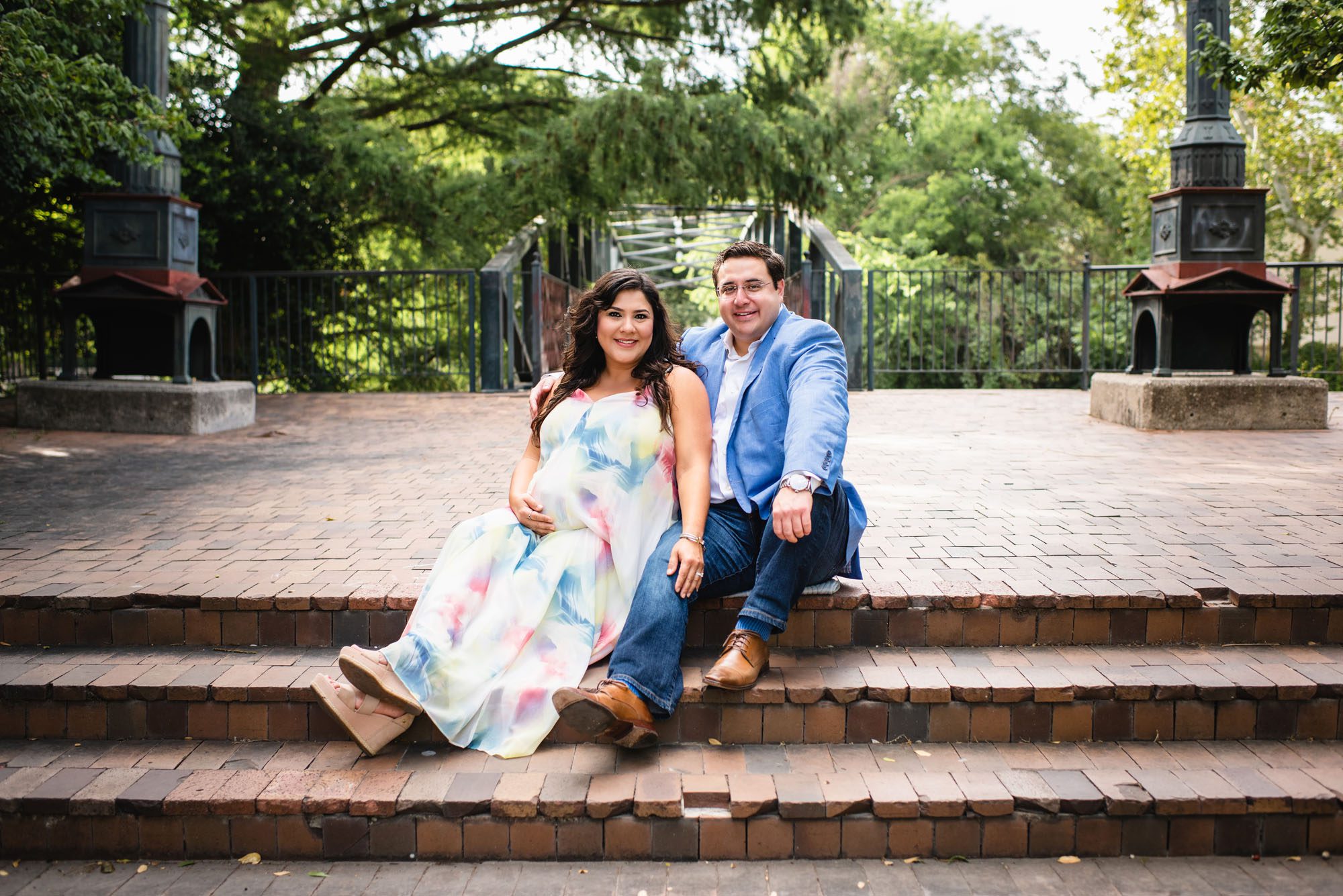 San Antonio Maternity Photographer, Pregnant mom and father sitting by bridge