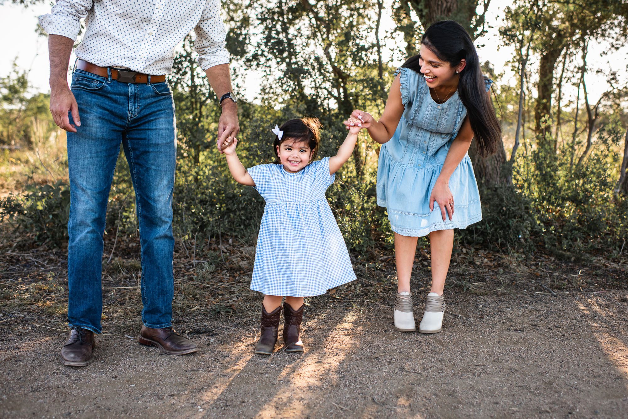 Parents holding daughter's hands, San Antonio family photographer