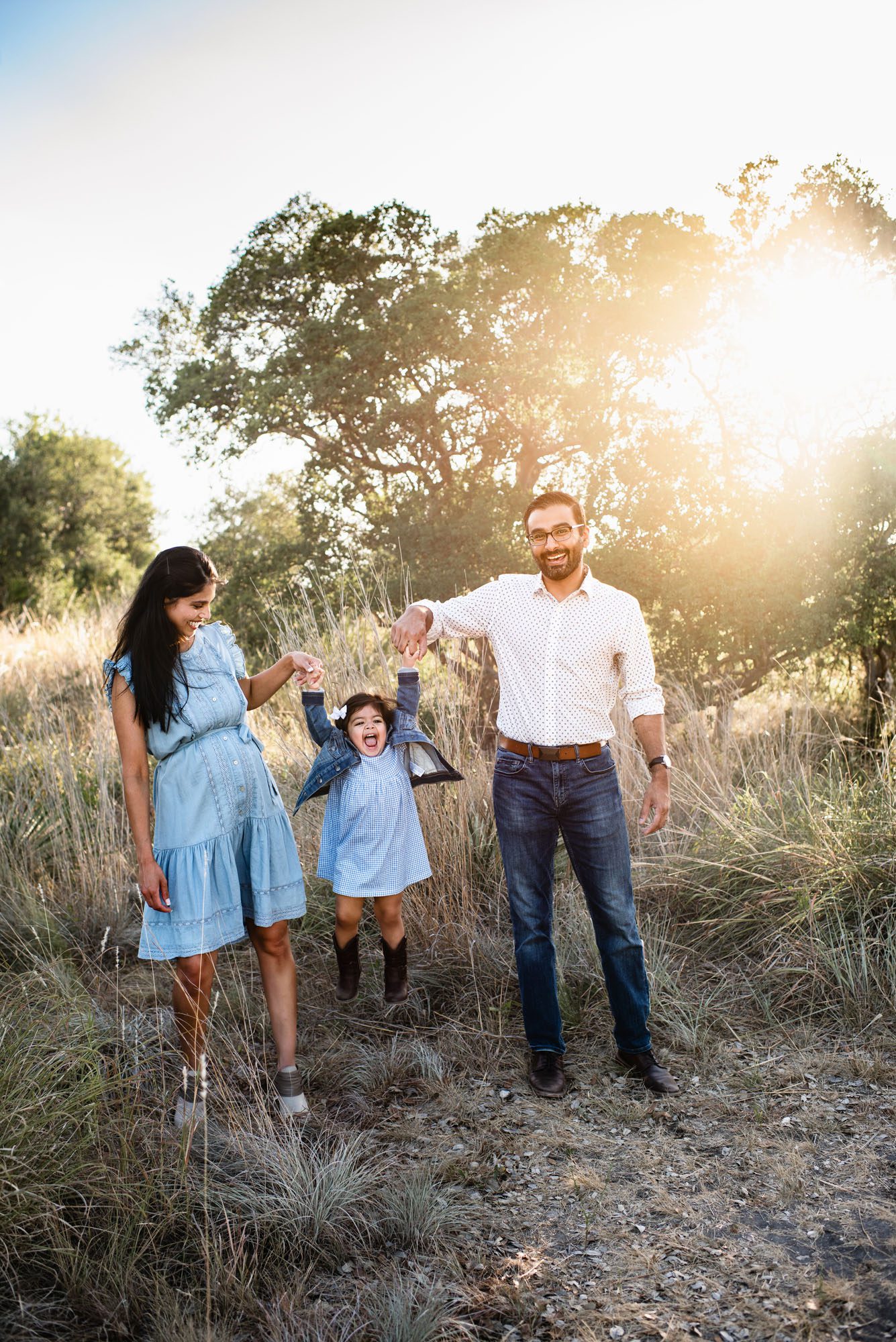 Parents playing with daughter in a field, San Antonio maternity photographer