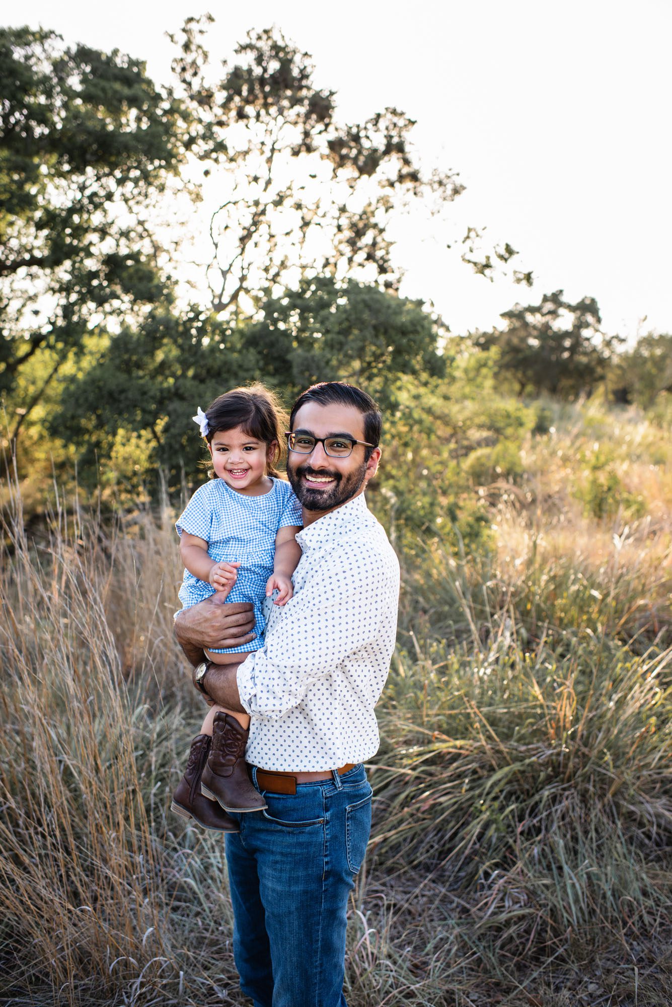 Father holding daughter in a field at sunset, San Antonio family photographer