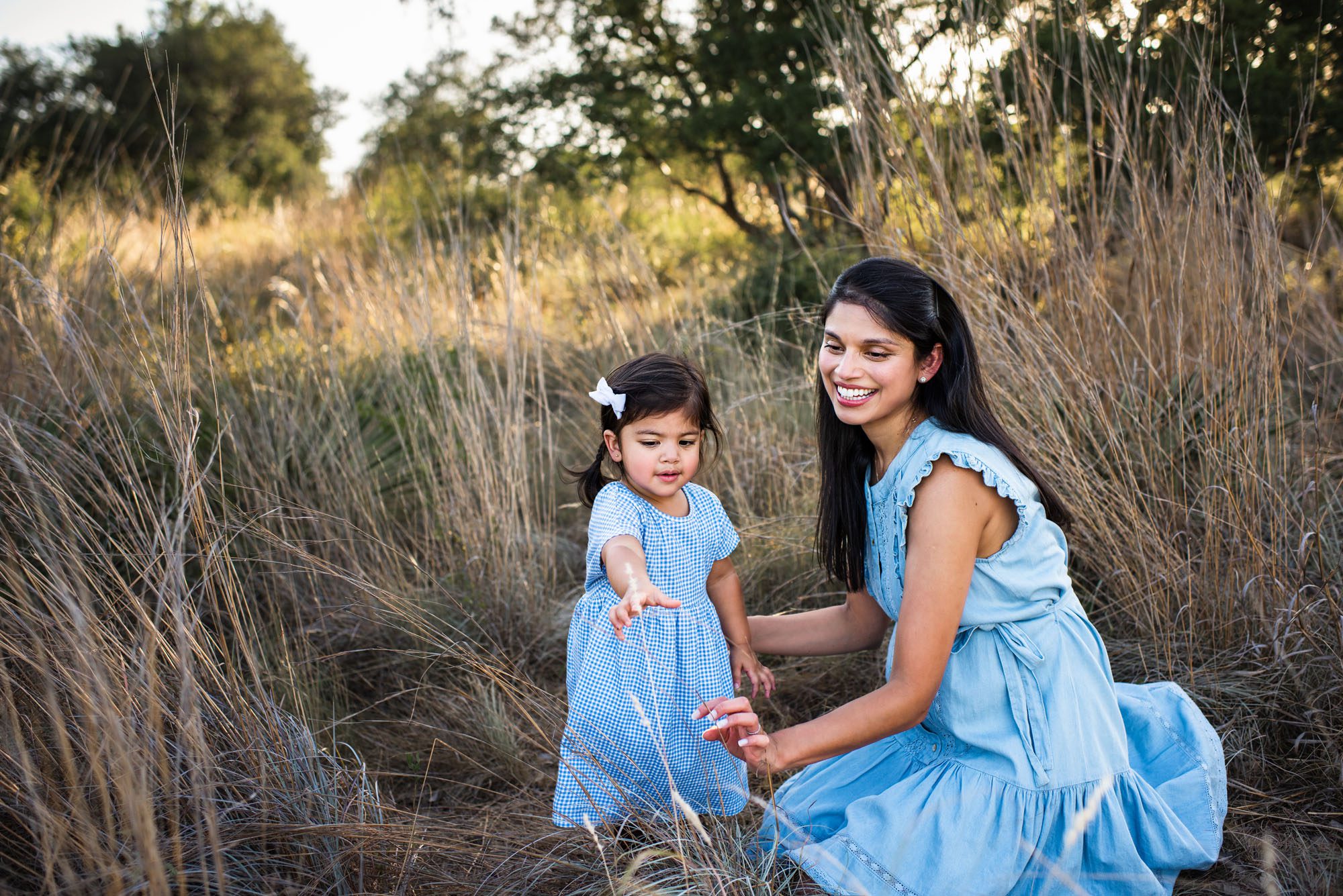 Daughter handing mother a piece of wheat in a field, San Antonio Maternity Photographer