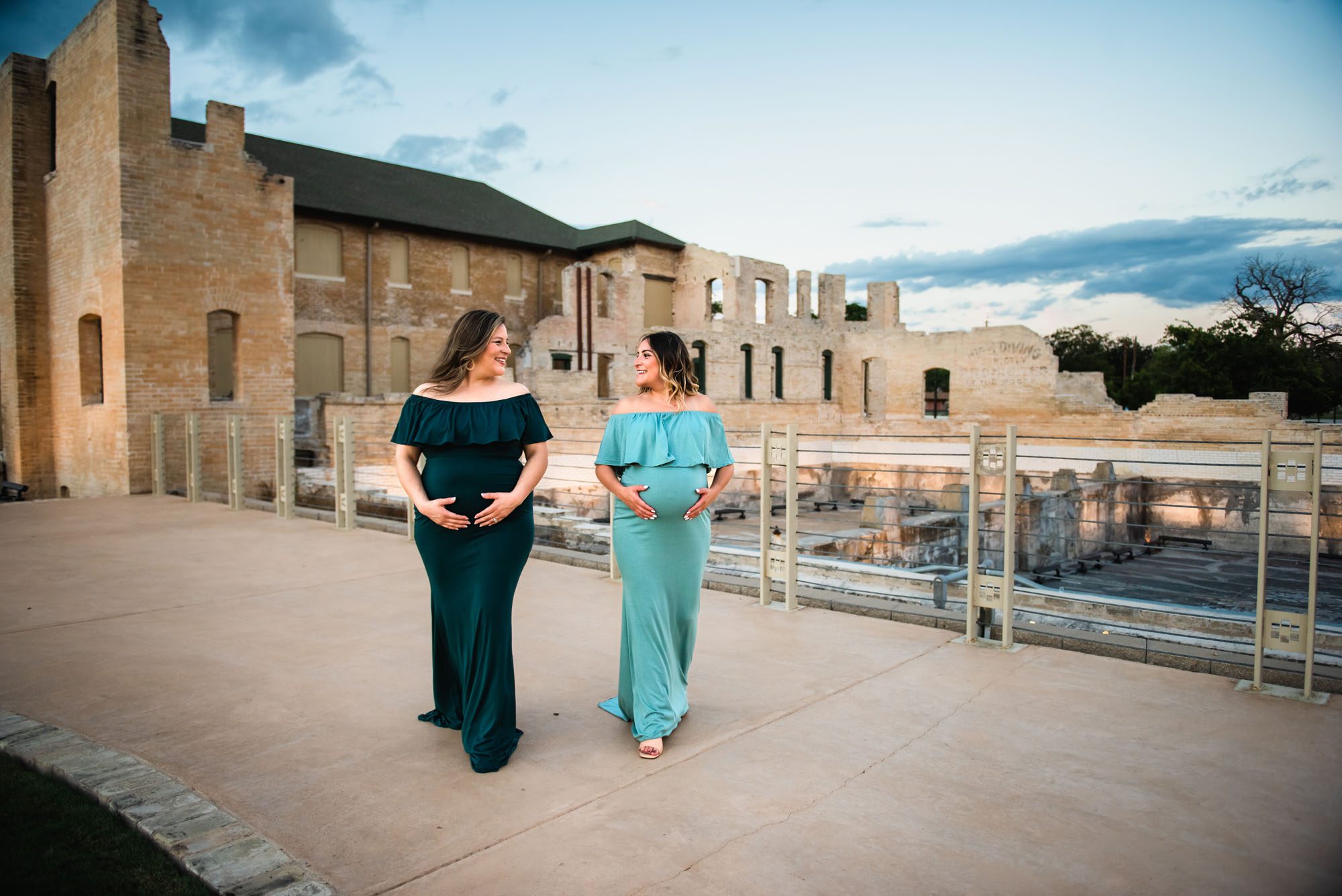 Pregnant sisters walking together by building, San Antonio Maternity Photographer