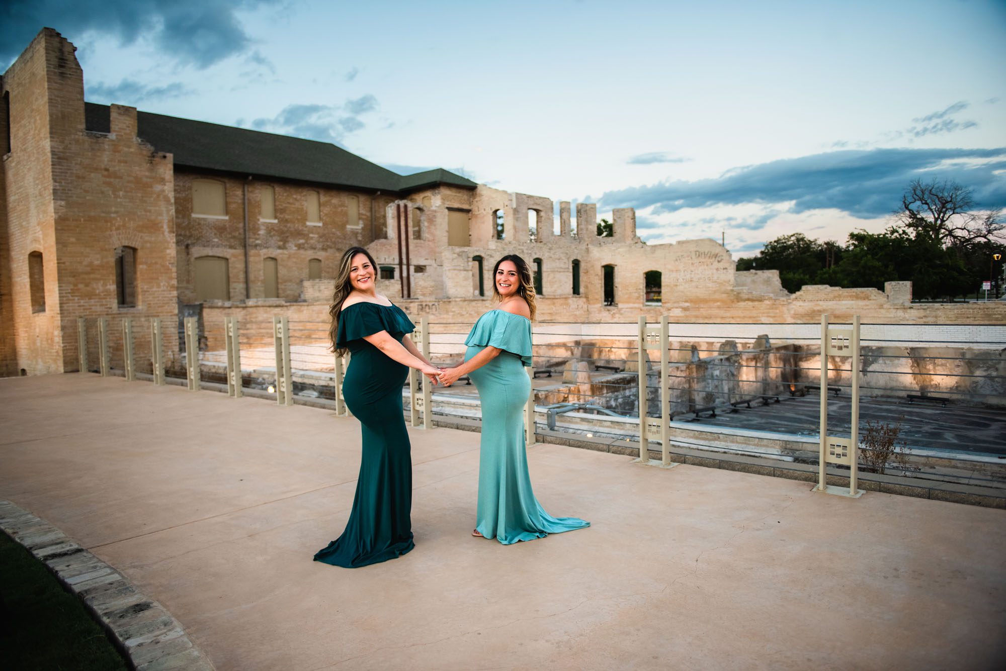 Pregnant sisters holding hands by building, San Antonio Maternity Photographer