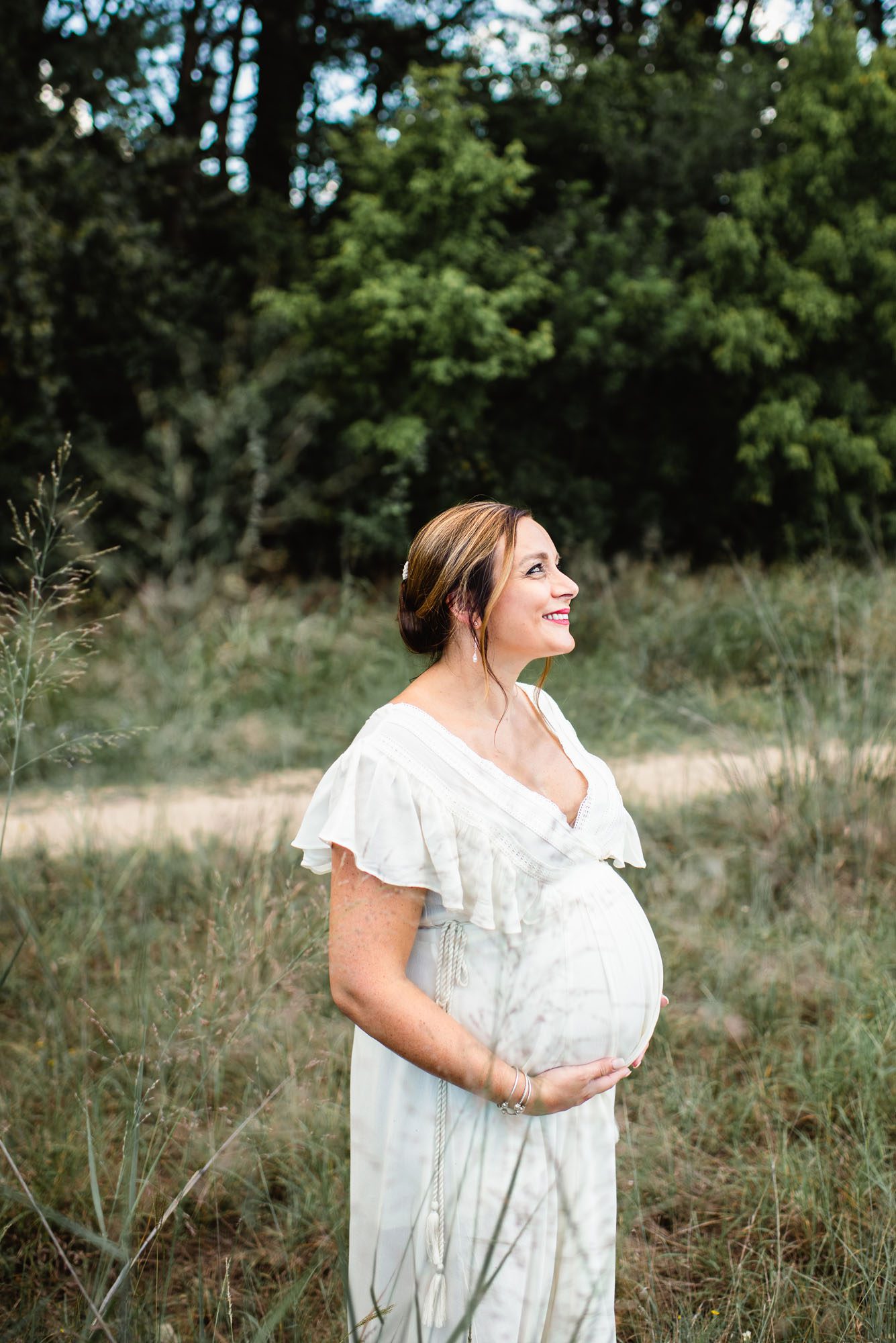 Pregnant mom smiling in a field, San Antonio maternity photographer